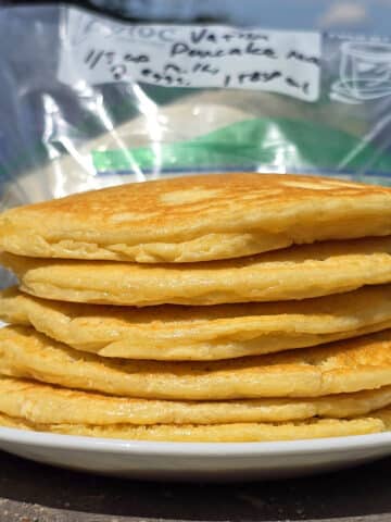 A plate of camping pancakes, in front of a bag of homemade protein pancake mix.