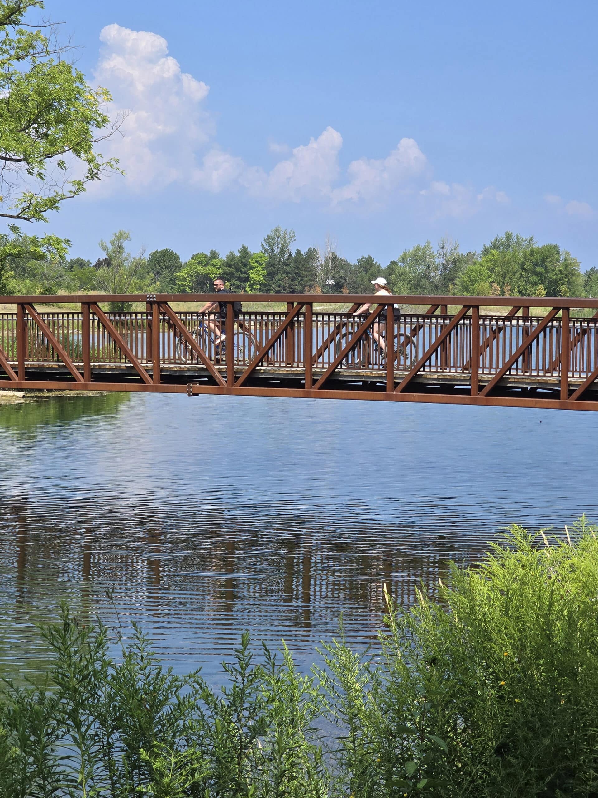 Two people cycling over a bridge at Fifty Point Conservation Area.
