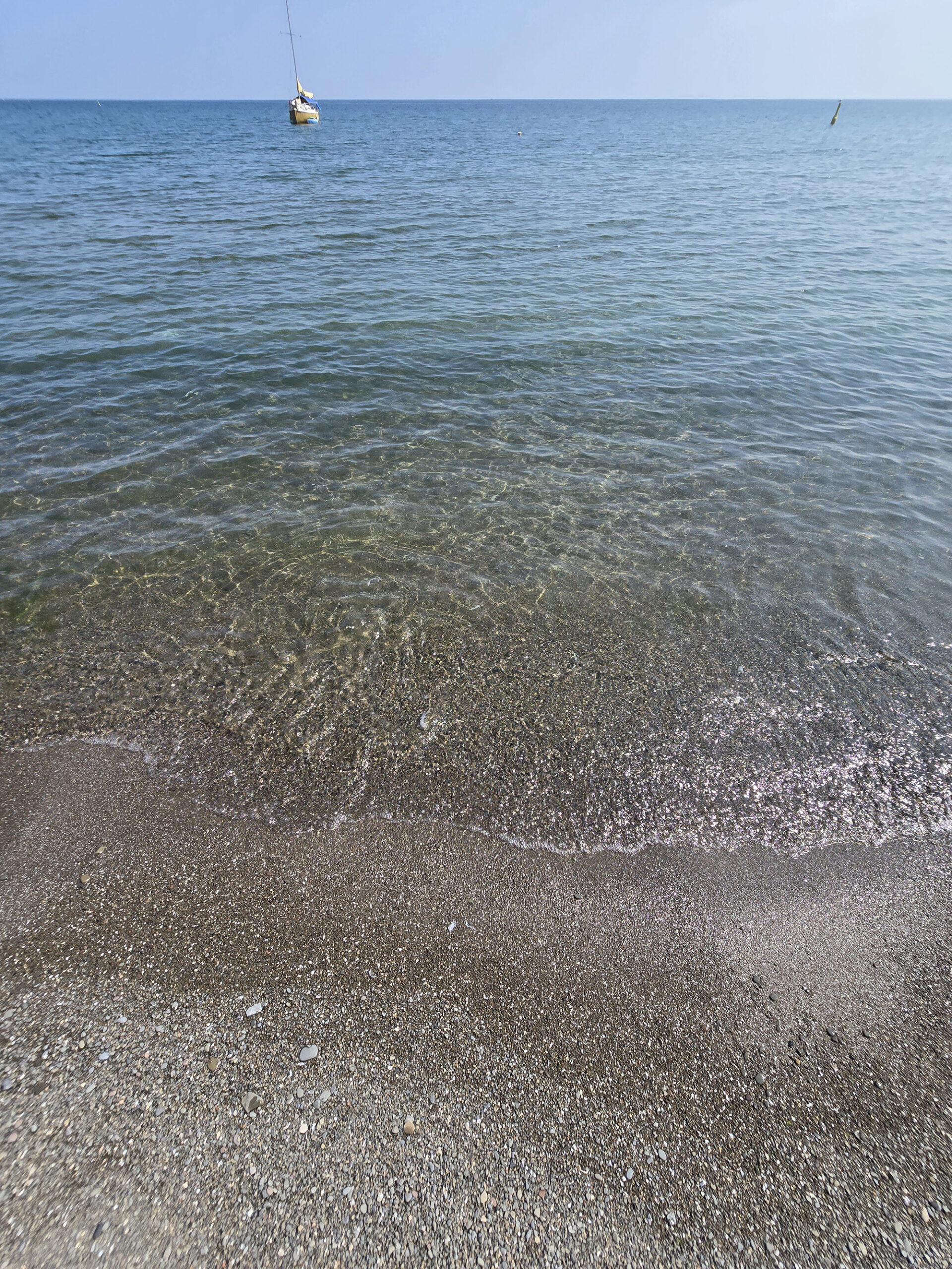 A close up view of the shoreline at Fifty Point Beach, with clear Lake Ontario water.