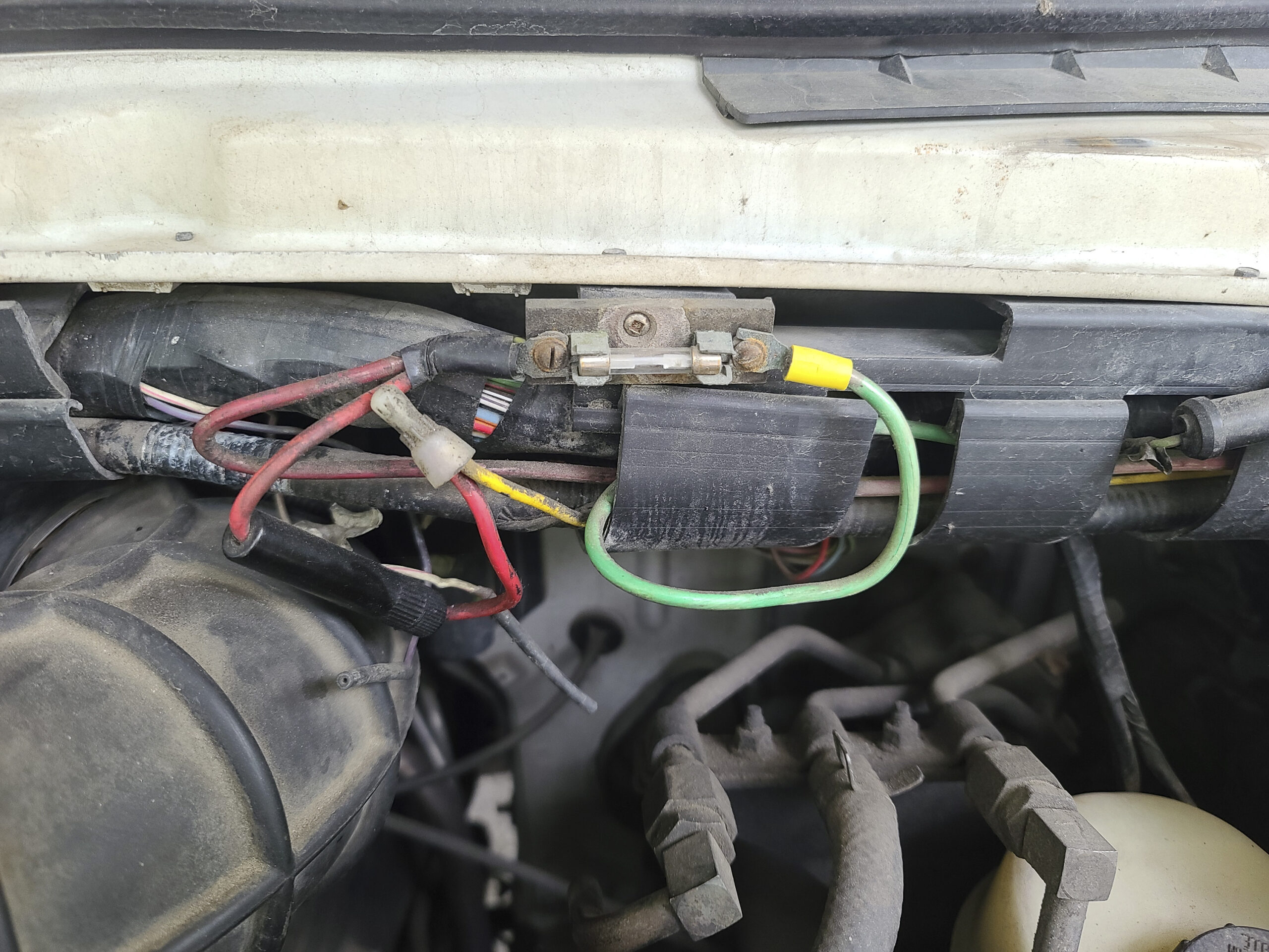 Under the hood of an RV, showing an inline fuse and wires.