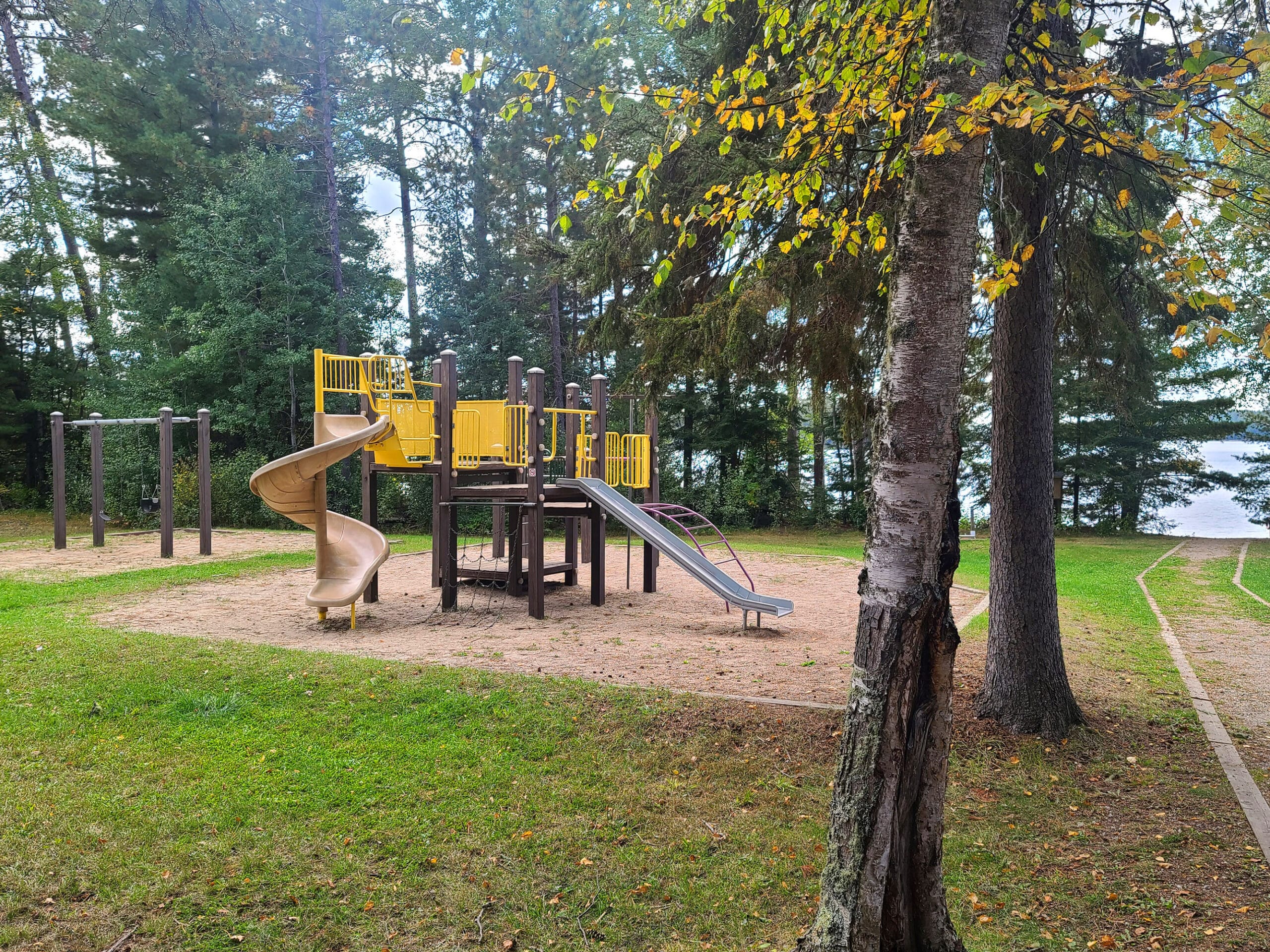 A large play ground structure in the woods.