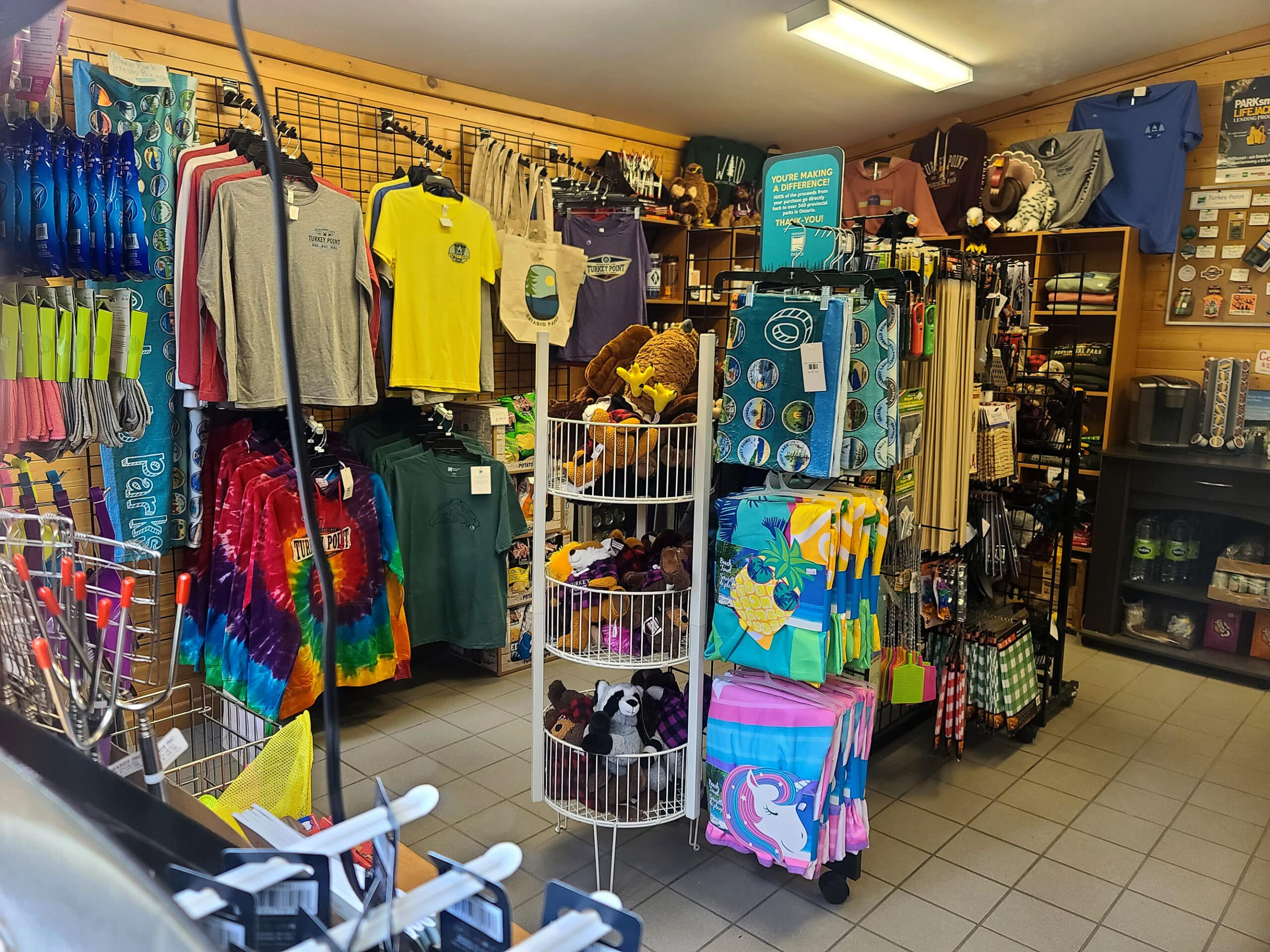 The inside of a campground store, with racks of shirts and souvenirs visible.