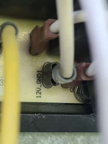 A closeup of the control board of an RV fridge. Wires are seen connected to the circuit board, and one is labelled as a 12v connection.