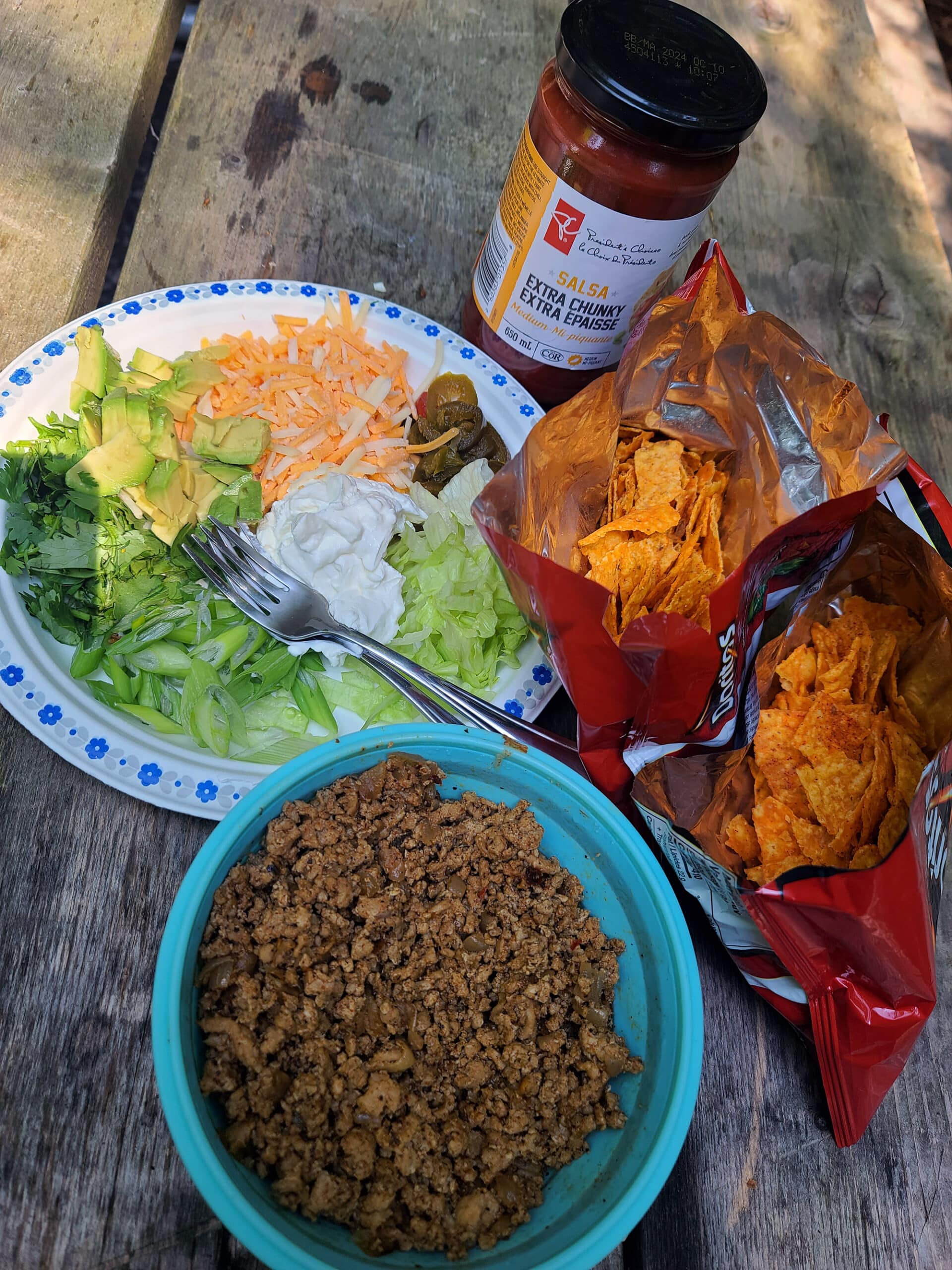 2 open bags of doritos next to all of the walking tacos ingredients.