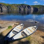 2 canoes on the shore of upper mazinaw lake on a sunny afternoon.