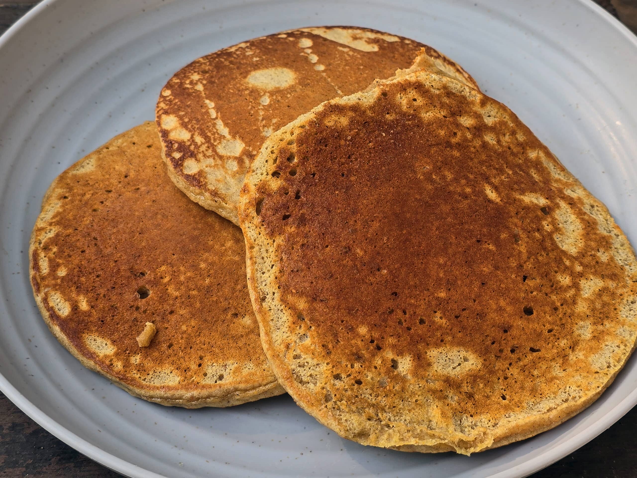 3 pumpkin protein pancakes on a camping plate.