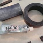 A sandpaper block, a roll of magnet strip, and a tube of E-6000 glue.