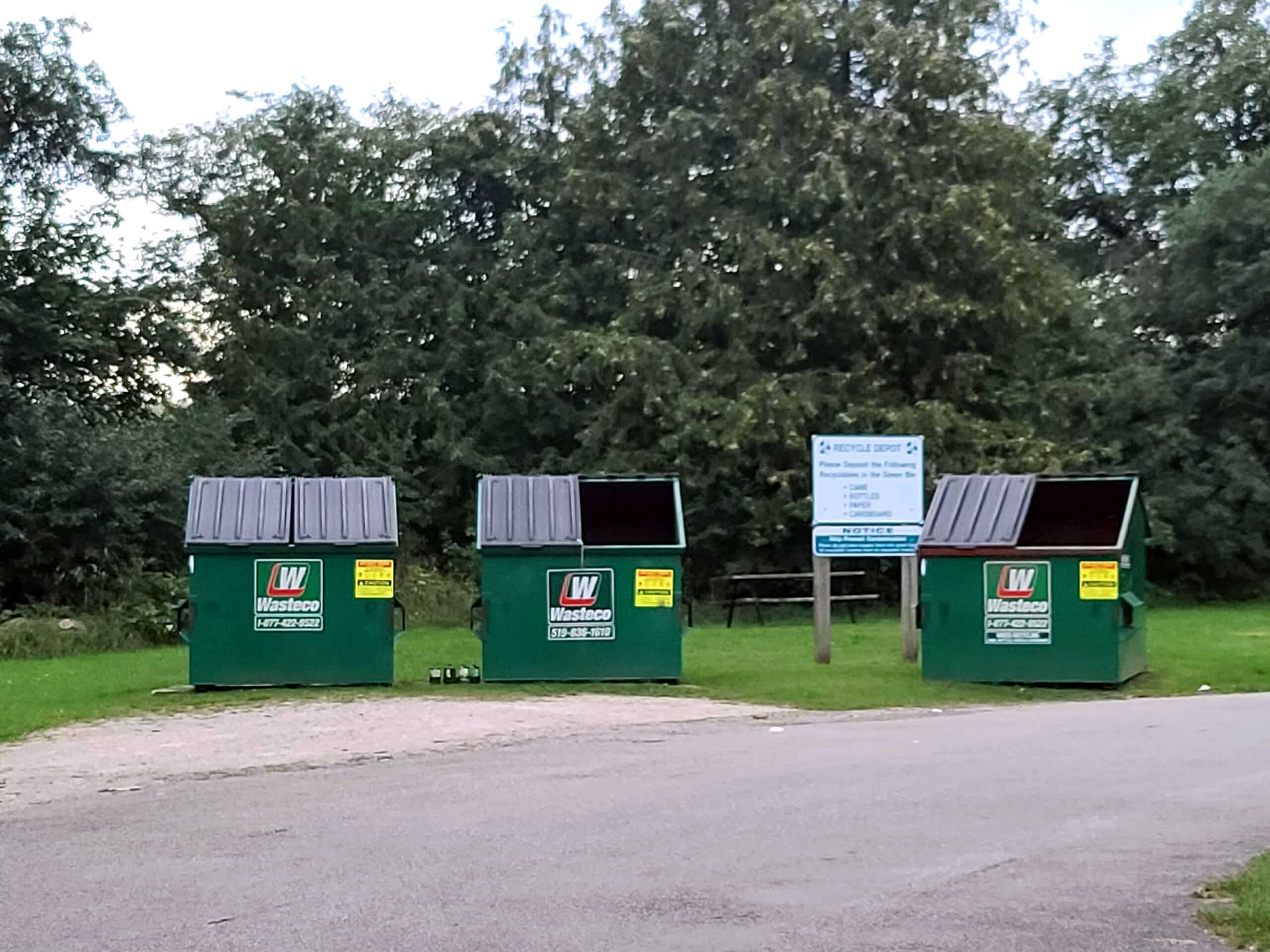3 large green recycling bins.
