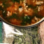 A bowl of gluten free soup next to a baggie of keto italian wedding soup mix.