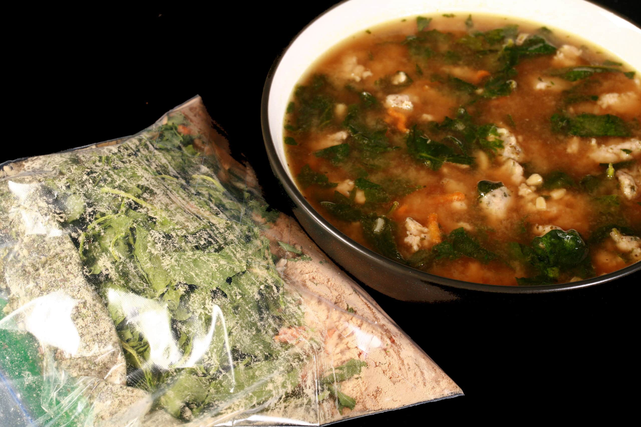 A bowl of soup next to a baggie of gluten free italian wedding soup mix.