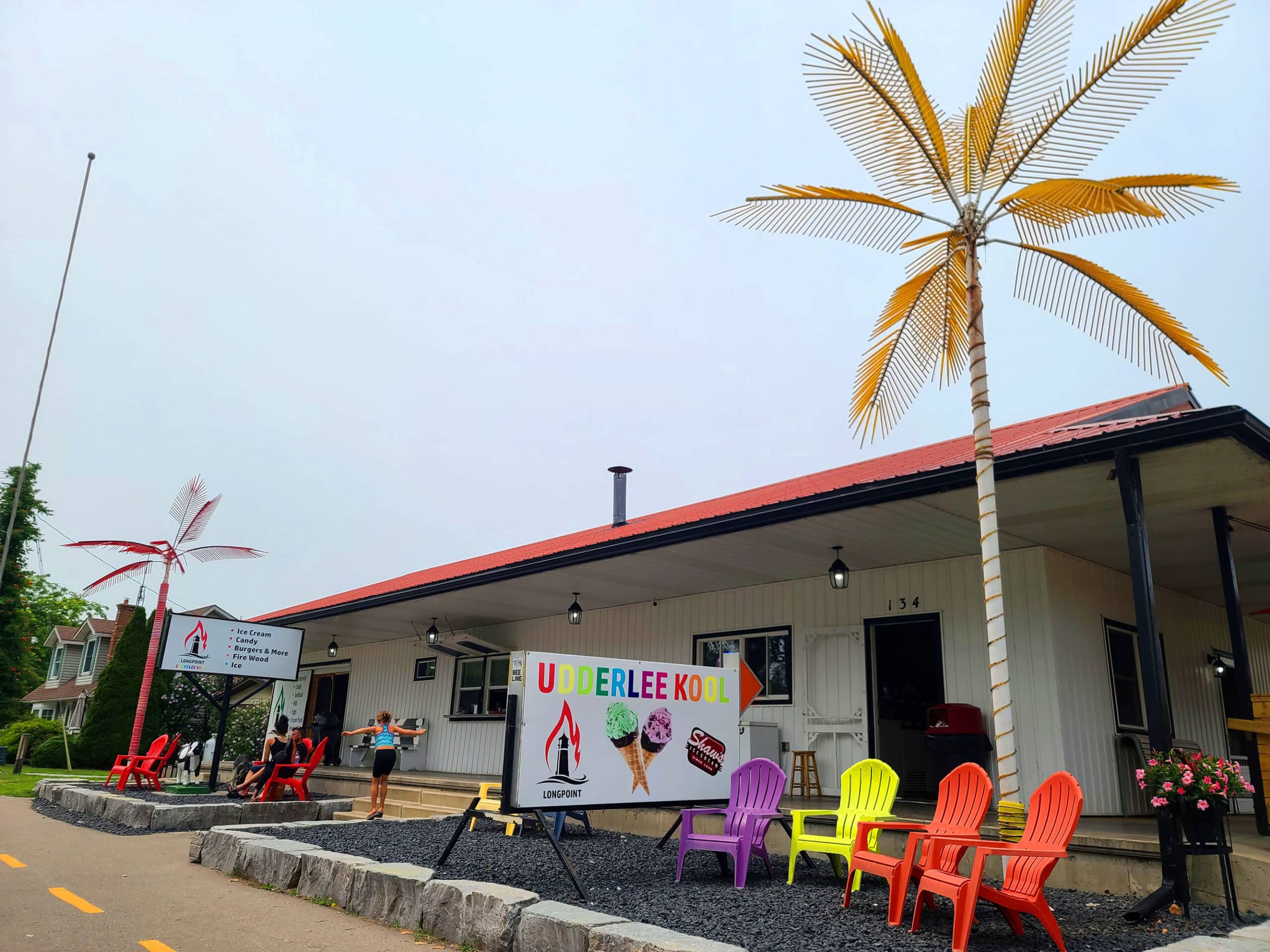 The underlee kool restaurant in long point.  There are 2 big metal palm trees in front.