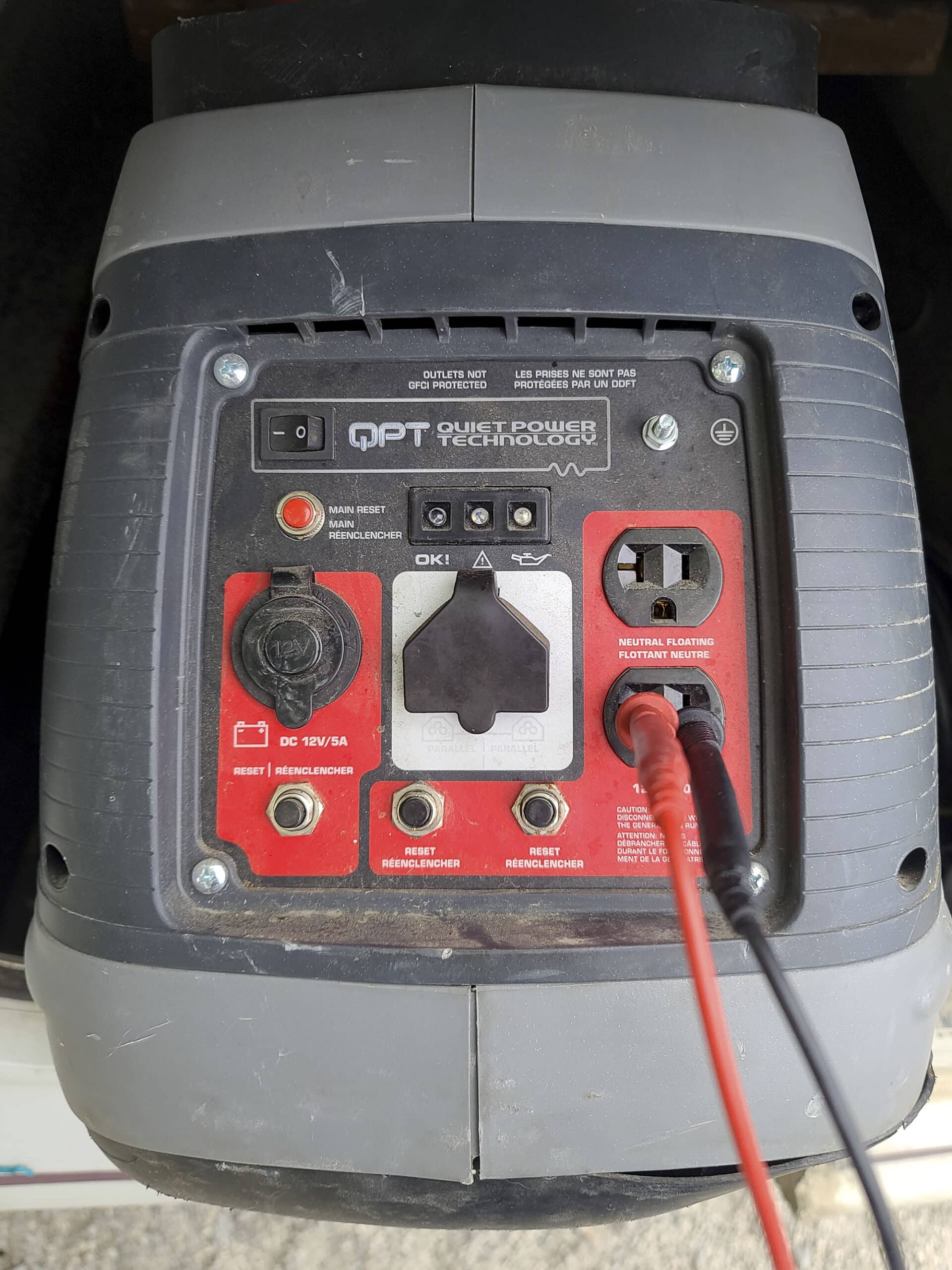 The front panel of a gray generator.  Plugs and buttons can be seen.
