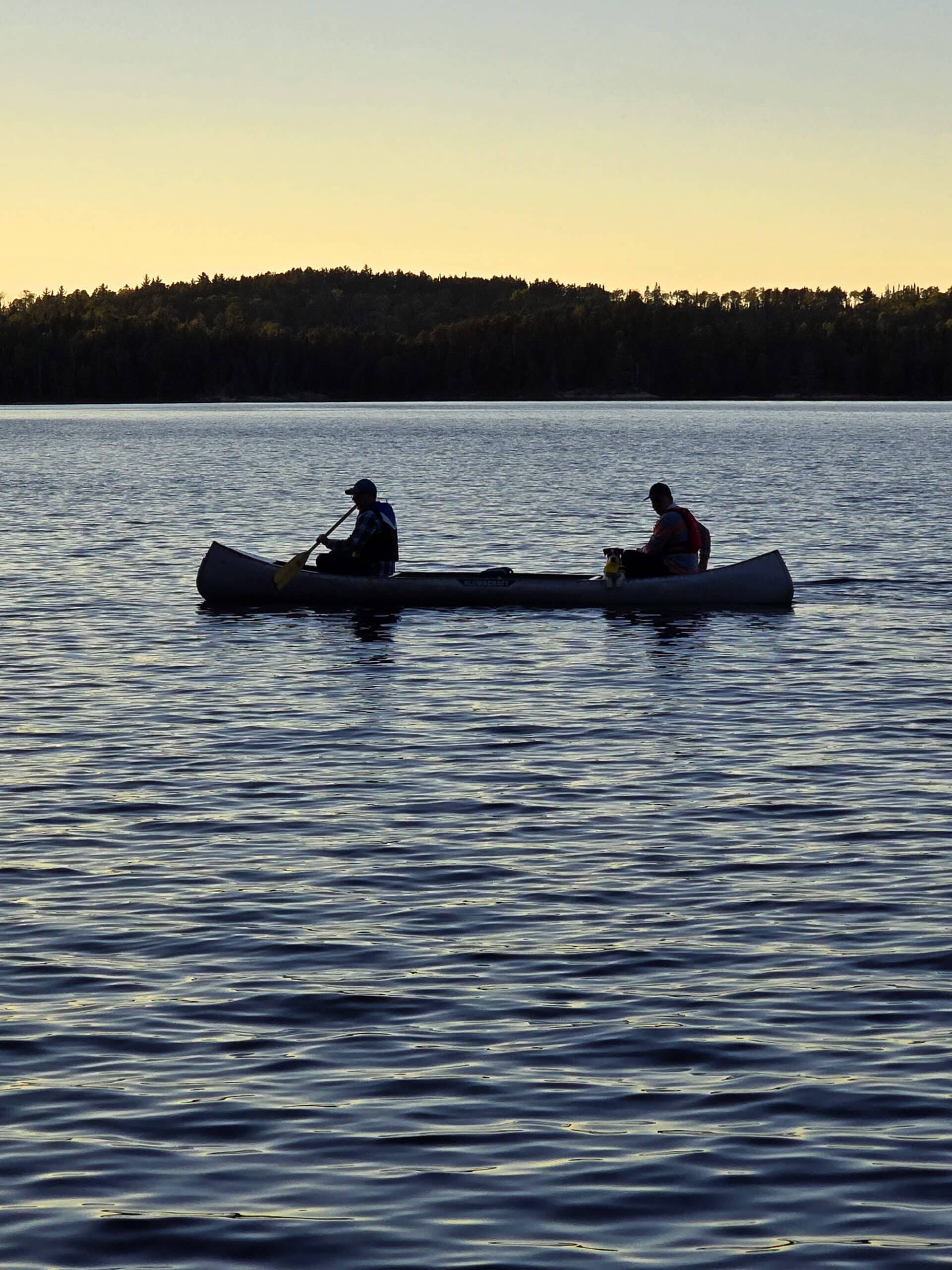2 men canoeing at sunset.