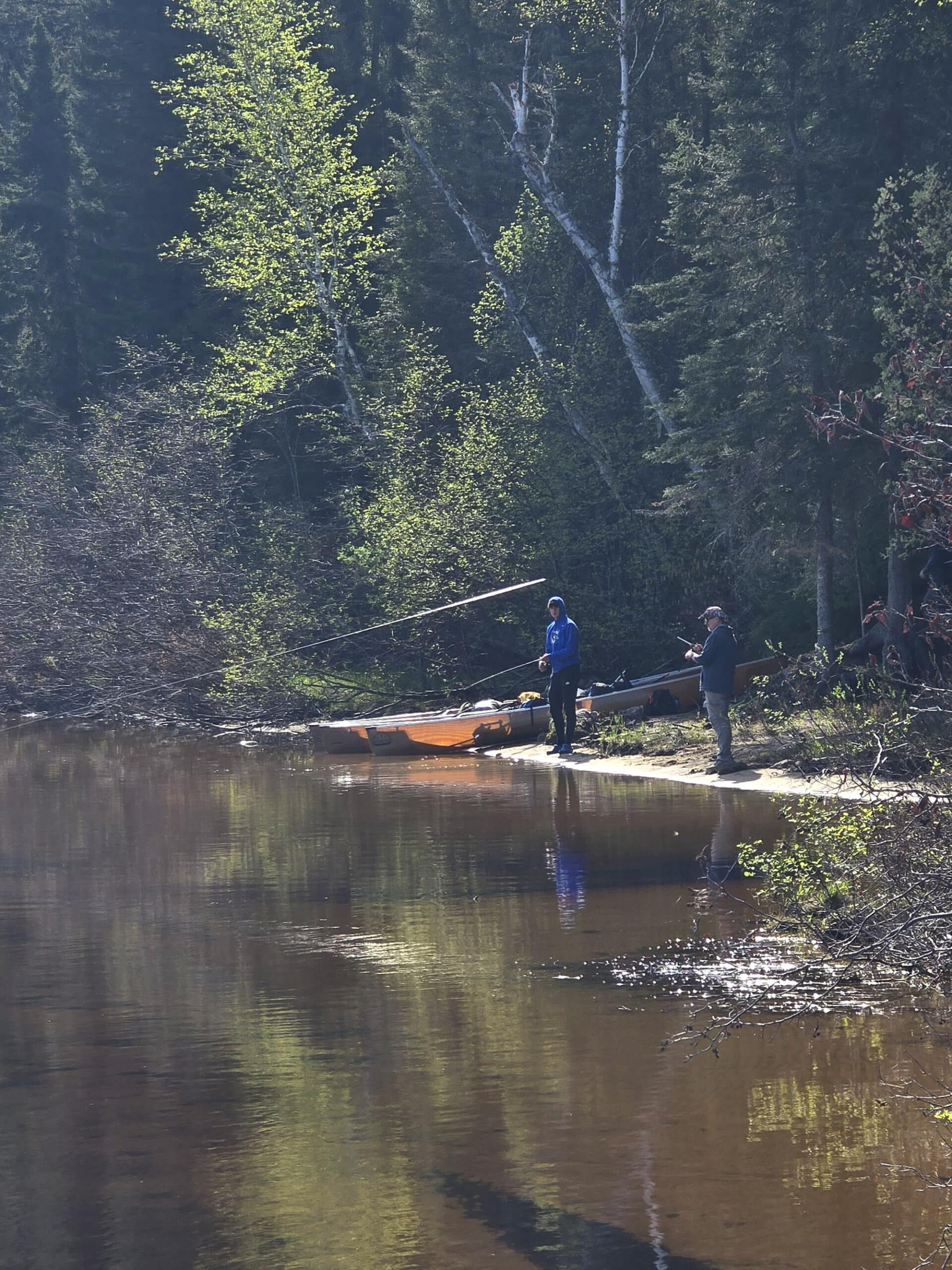 2 men fishing on the shore of a lake in Quetico Provincial Park.
