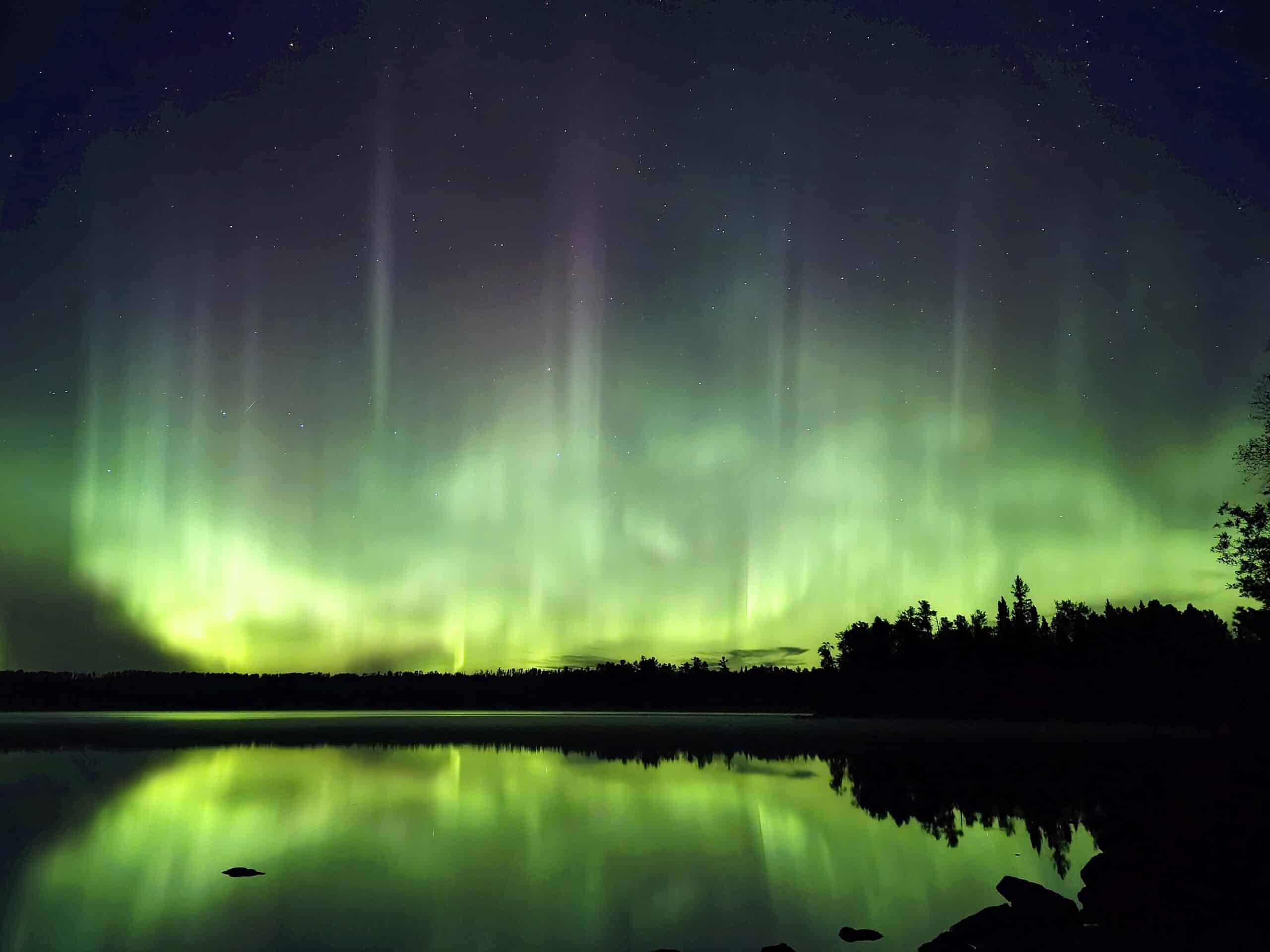 A bright green and purple aurora borealis at quetico provincial park.