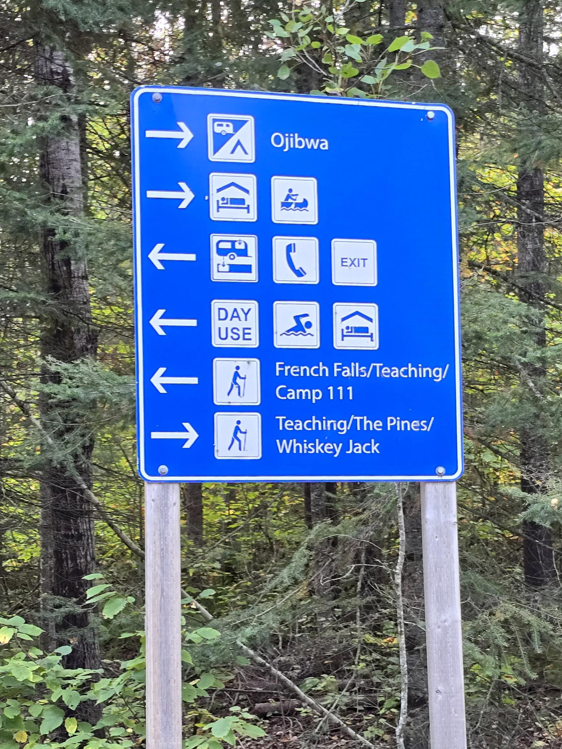 A blue and white campground road sign.