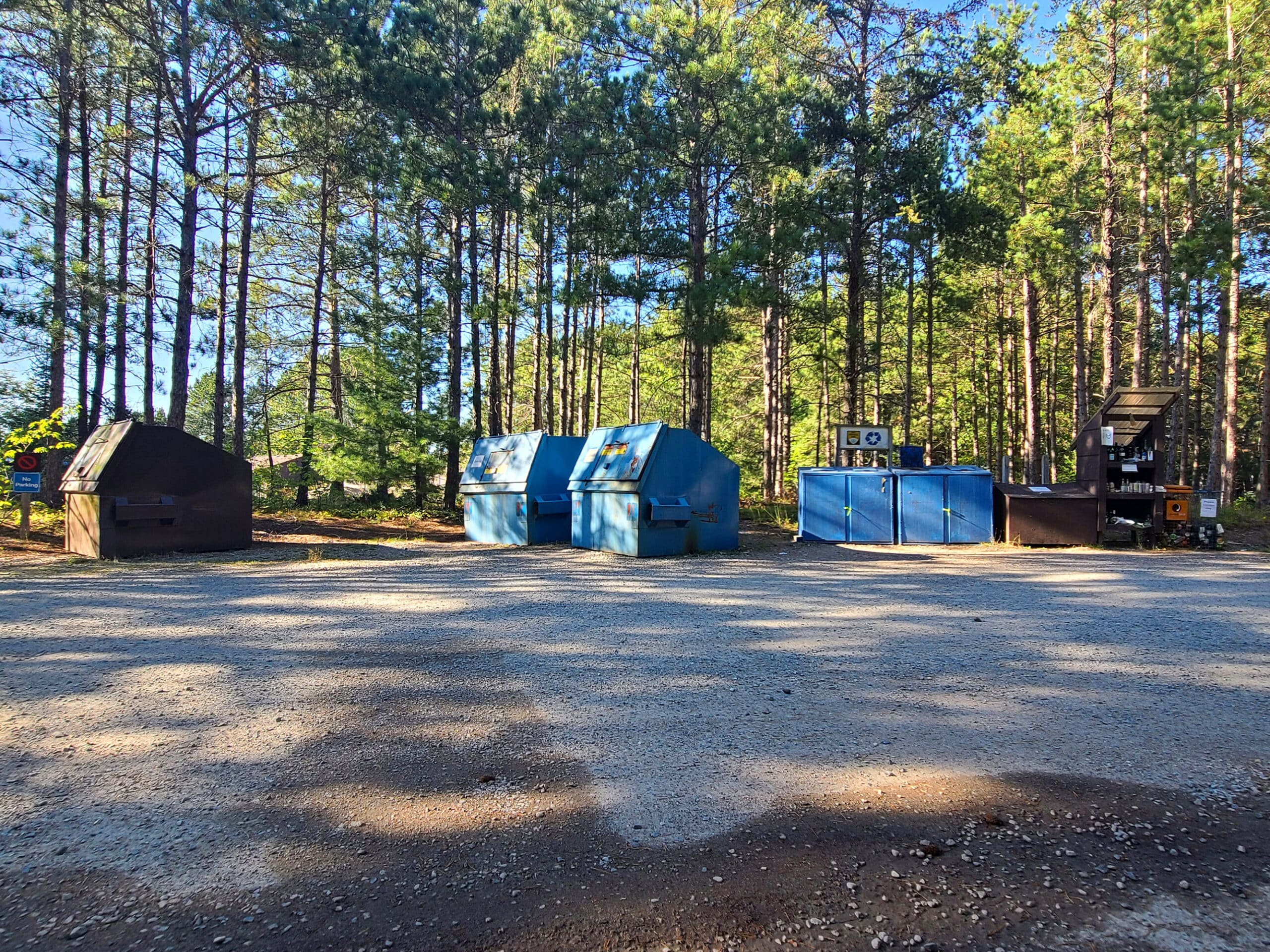 Several large campground garbage and recycling bins.