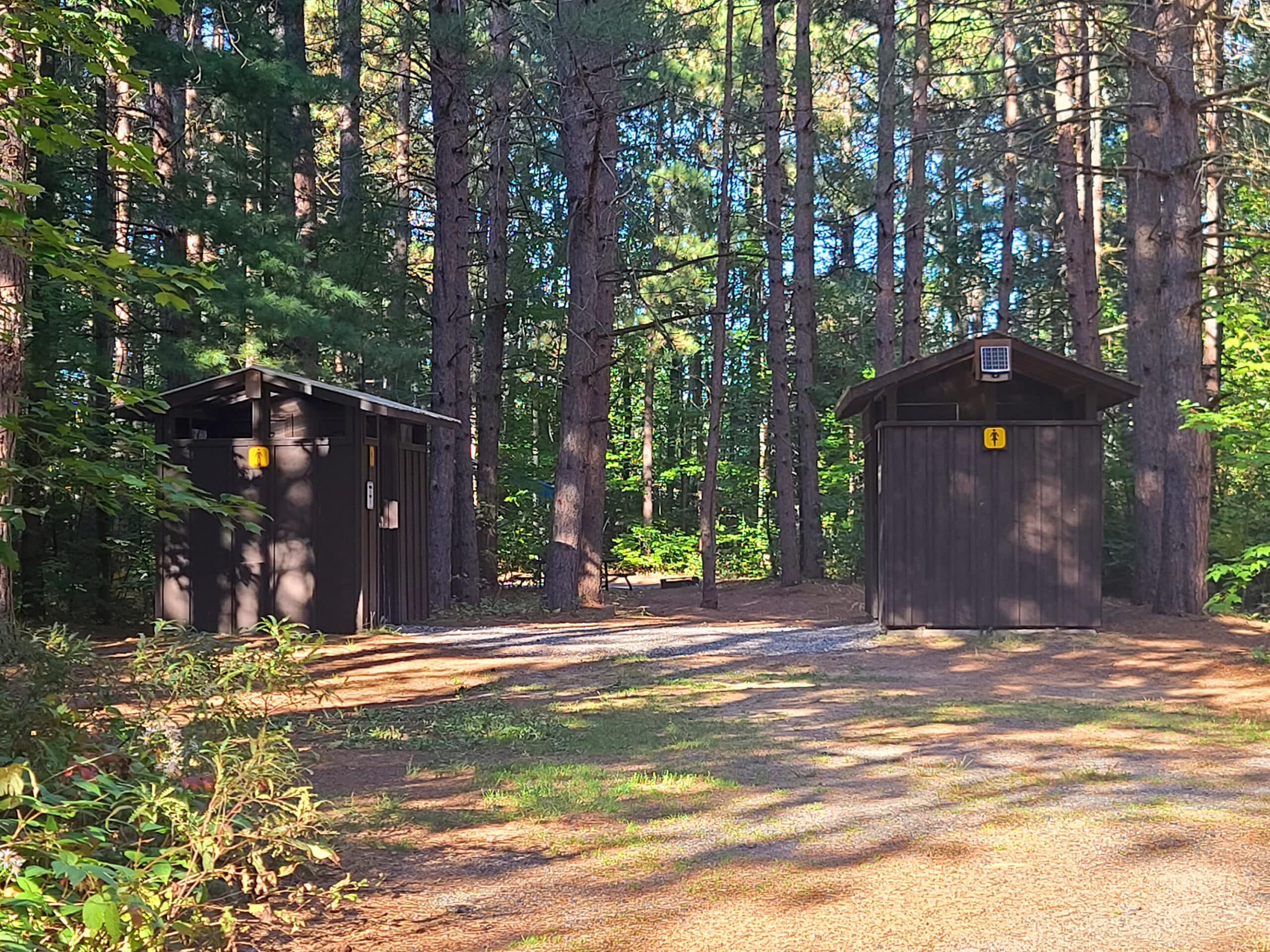 2 outhouses in a campsite.