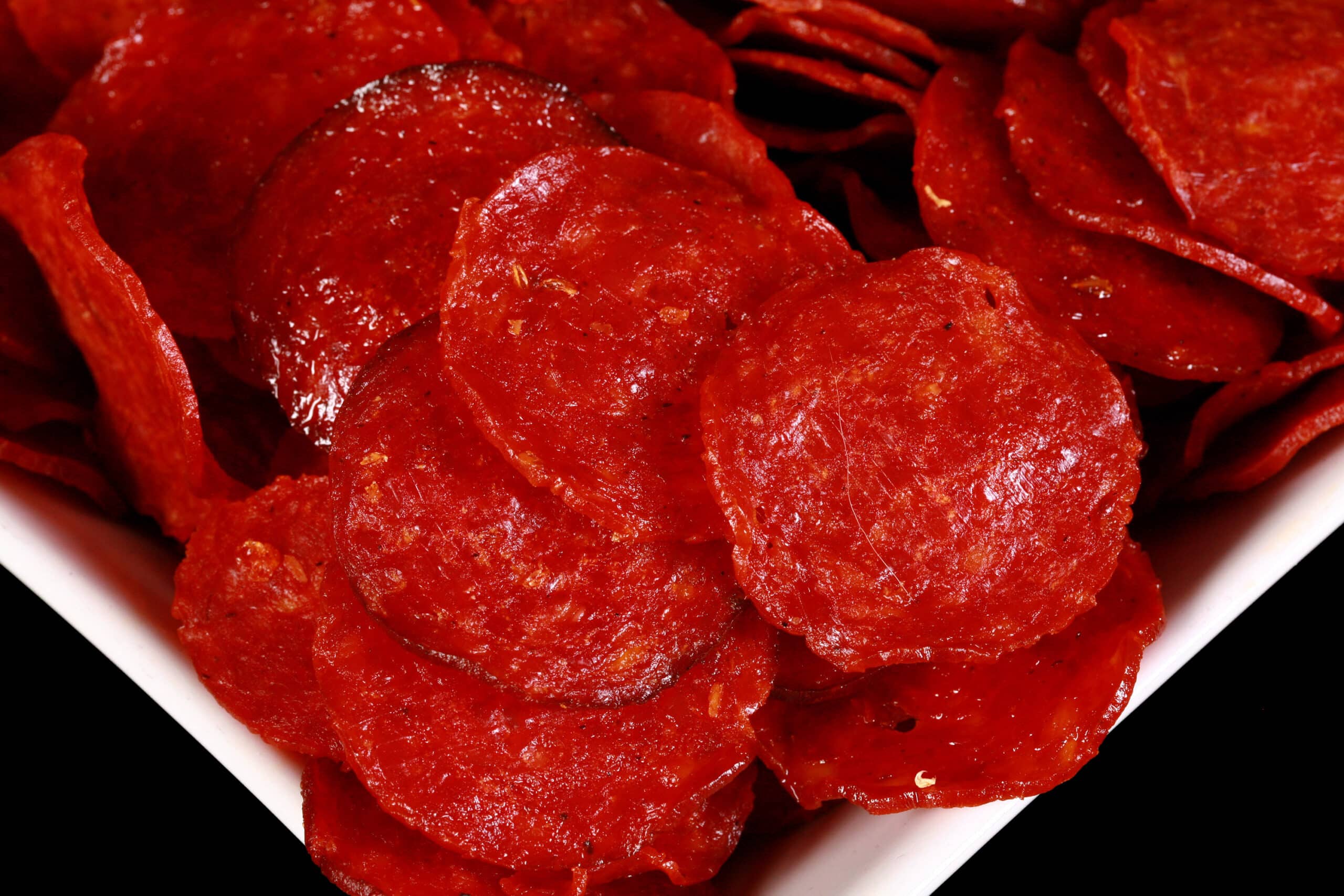A bowl of dehydrated pepperoni slices.