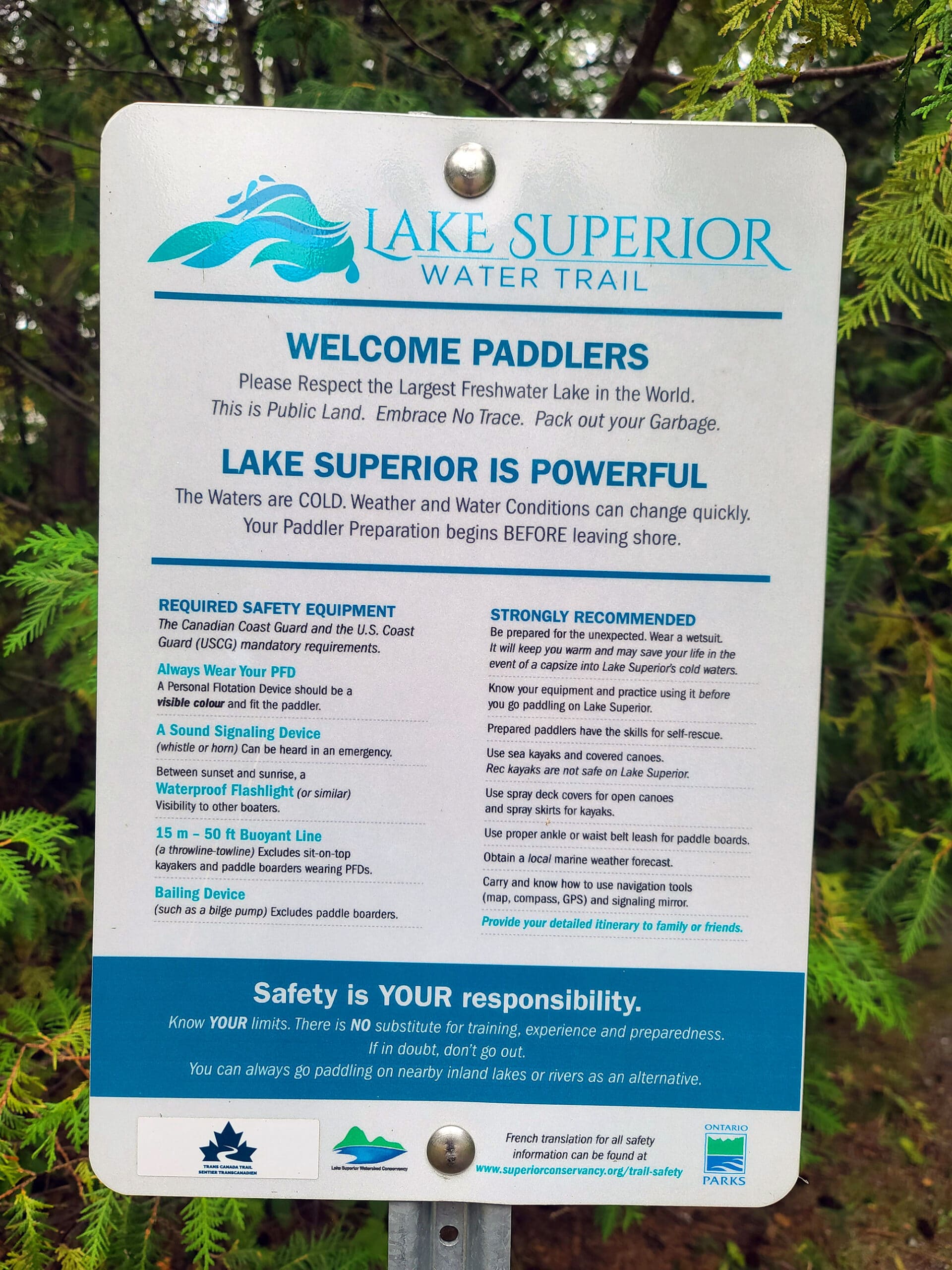 A park sign addressing paddlers to talk about the dangers of the local water.