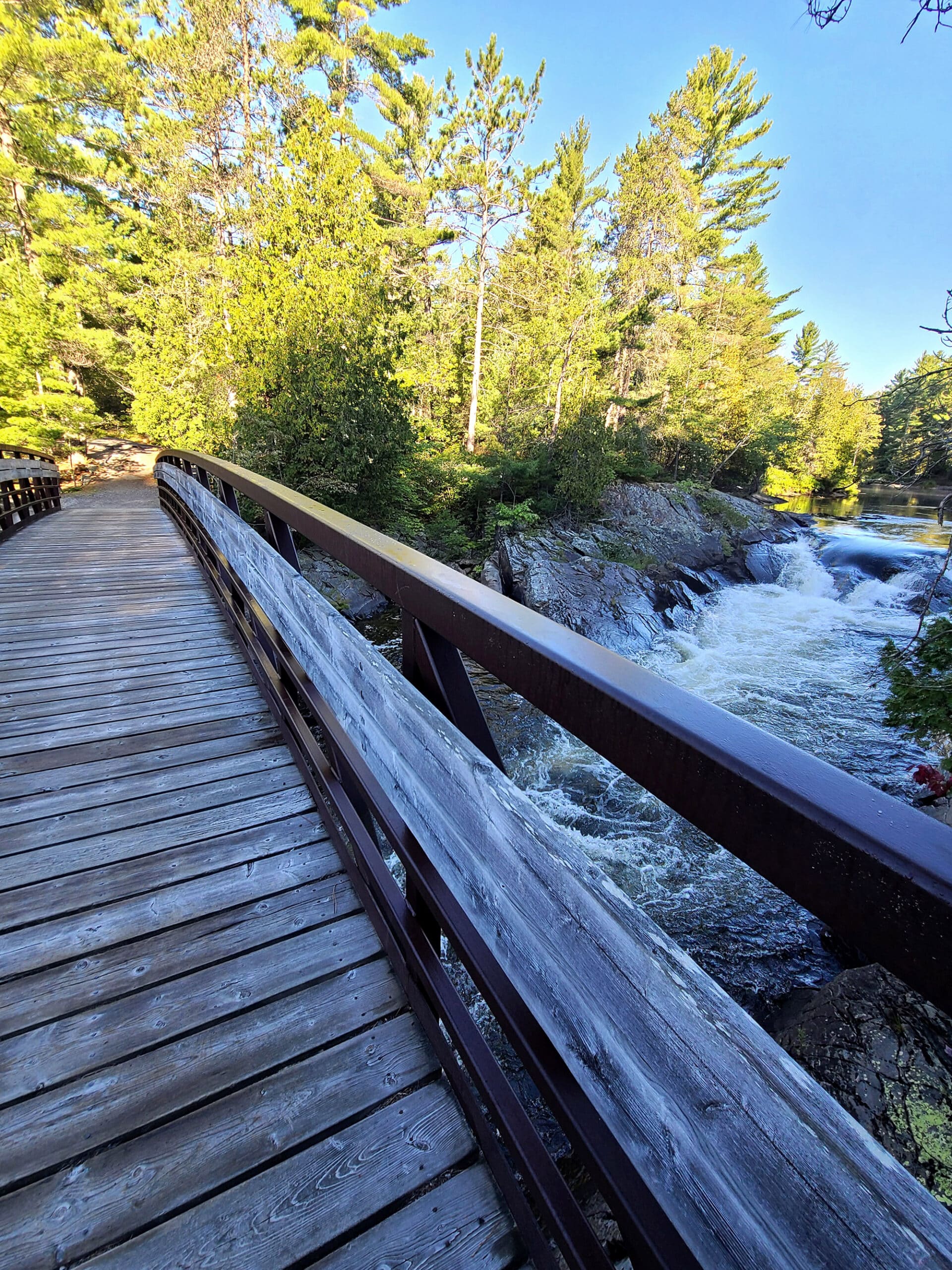 A wooden bridge crossing rapids.