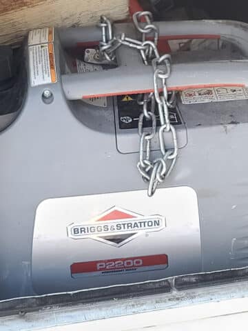 A gray portable generator in an exterior motorhome cubby.
