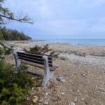 A part bench looking out over a rocky beach.