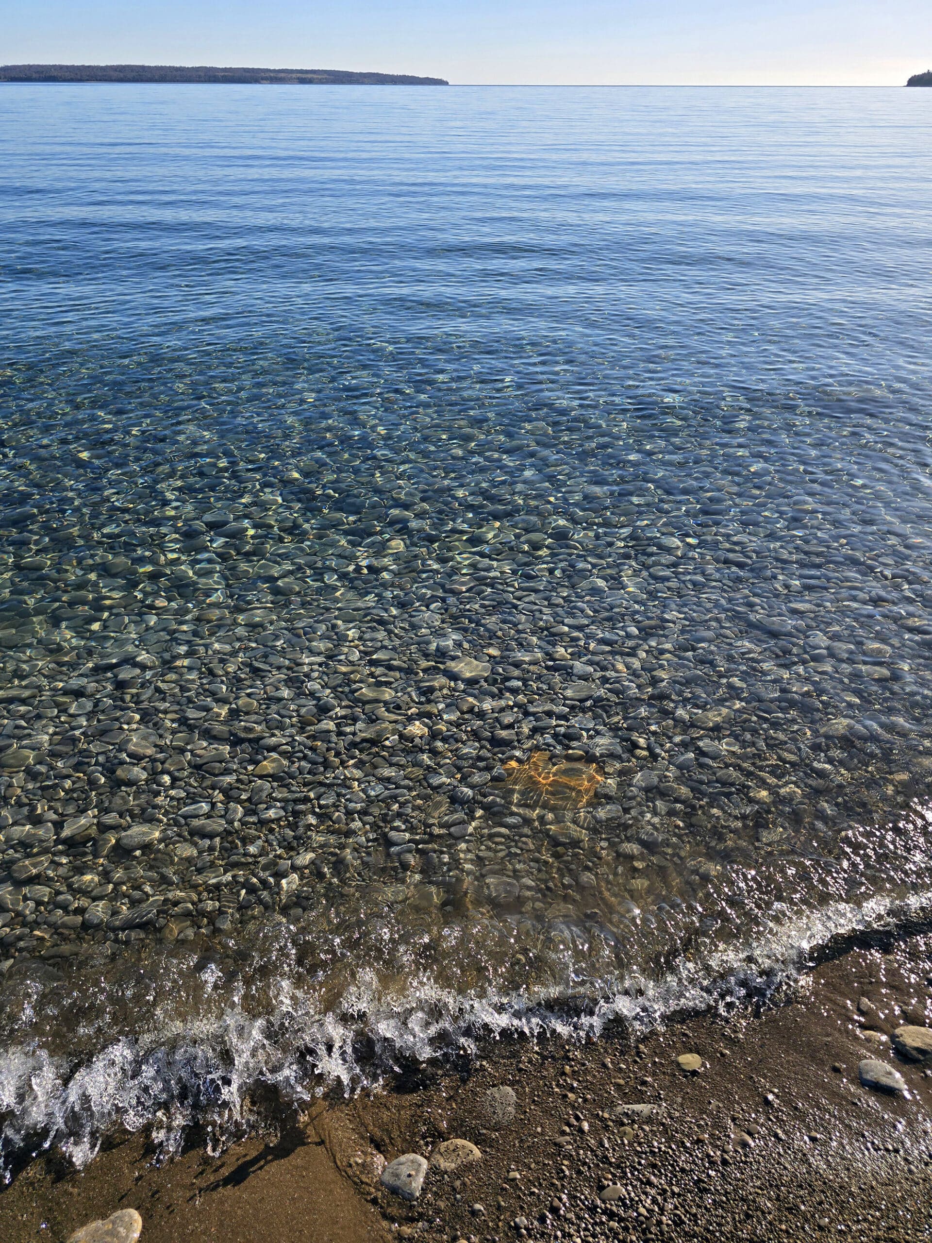 Big Bay’s shallow beach, with a rocky lake floor and turquoise water.