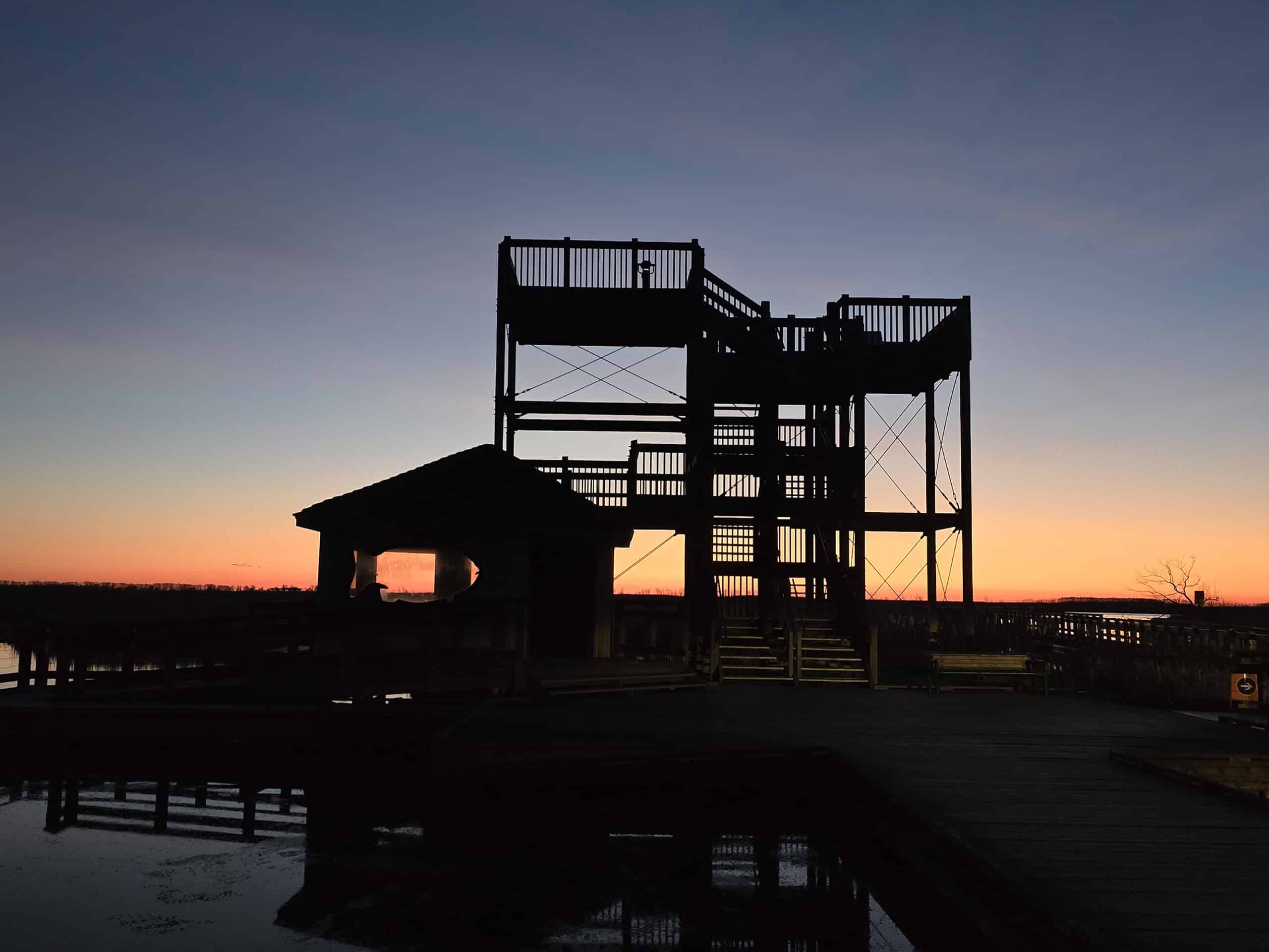 A sunset coming up behind the observation tower at the marsh boardwalk.