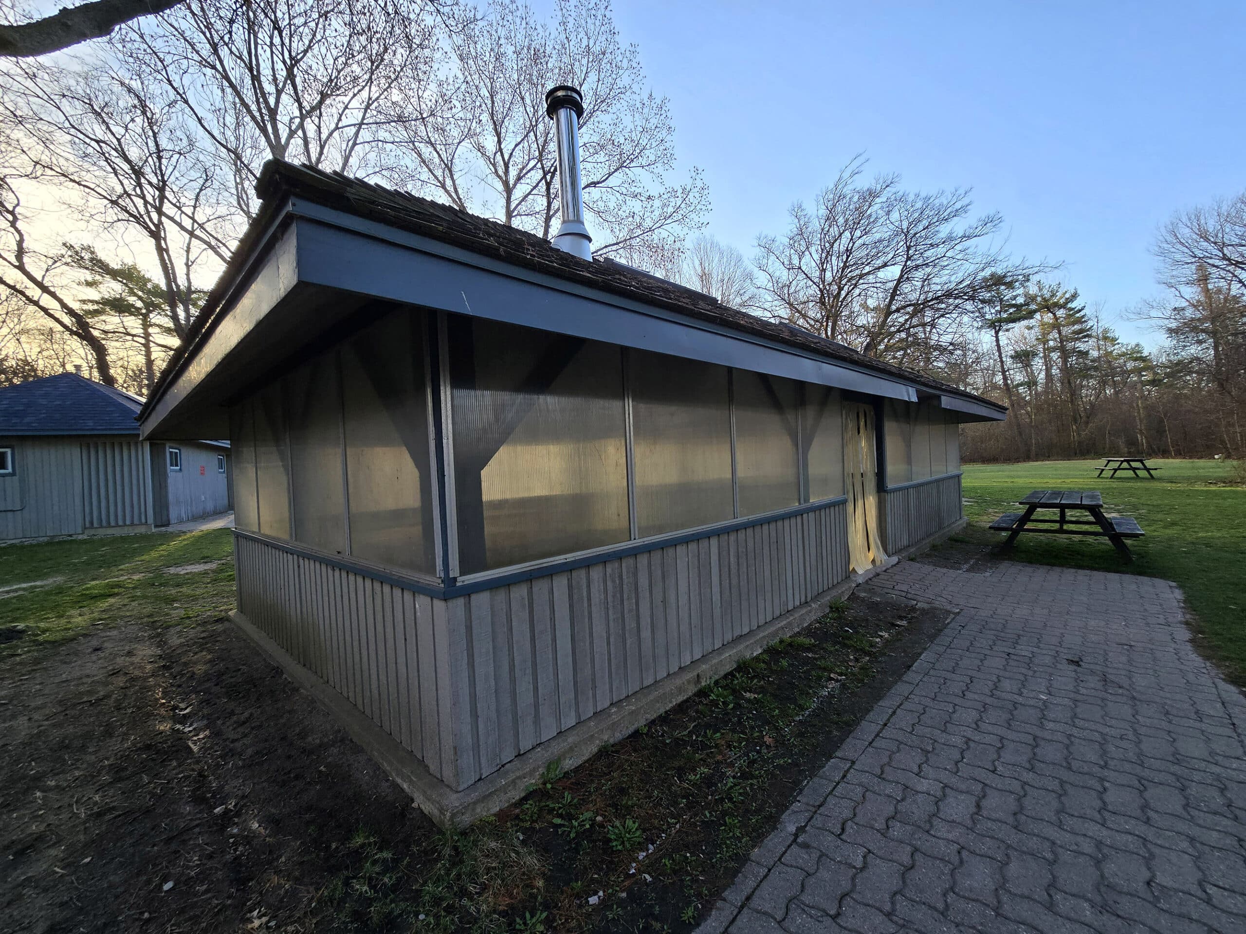 A small picnic shelter with plastic over the windows.