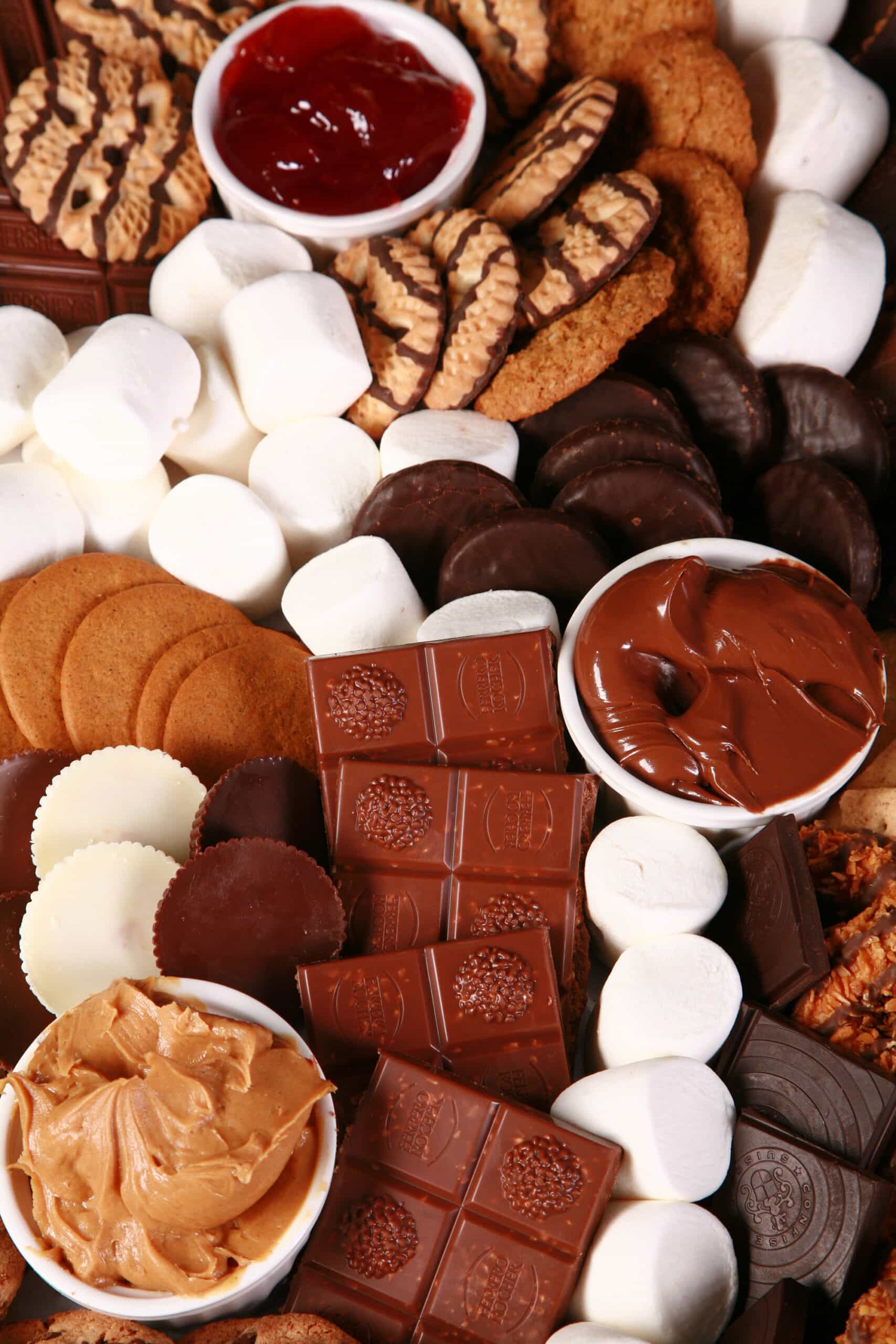 A s’mores tray, with ramekins of sauces, different kinds of cookies, chocolate, and marshmallows.