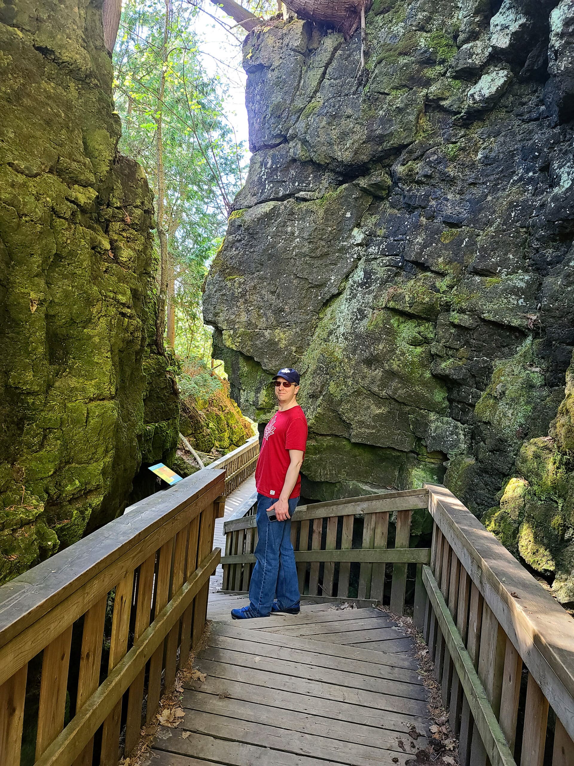 A middle aged white man on a boardwalk going between cliff faces at mono cliffs park.