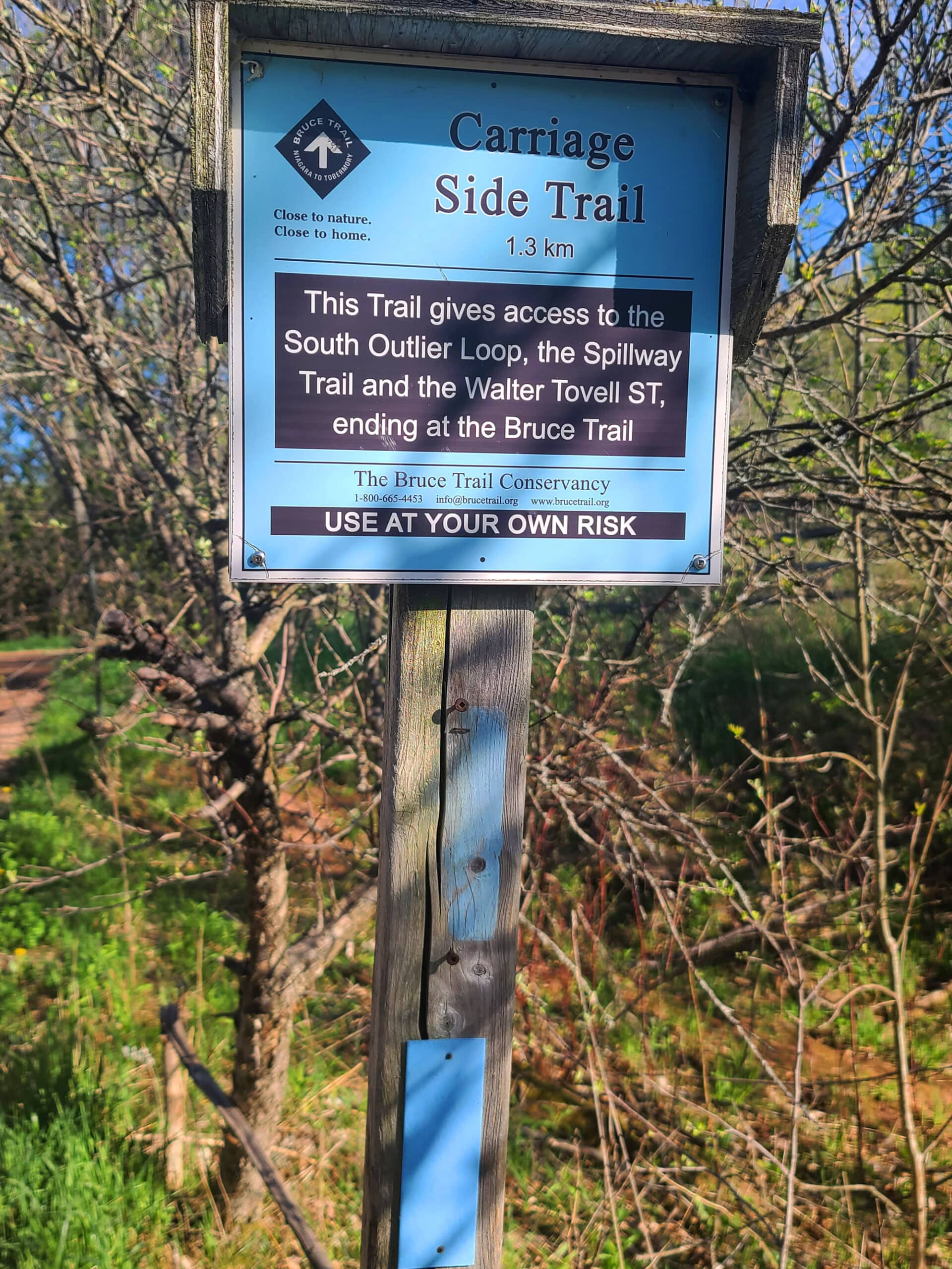 A blue trail sign giving information for the carriage side trail.