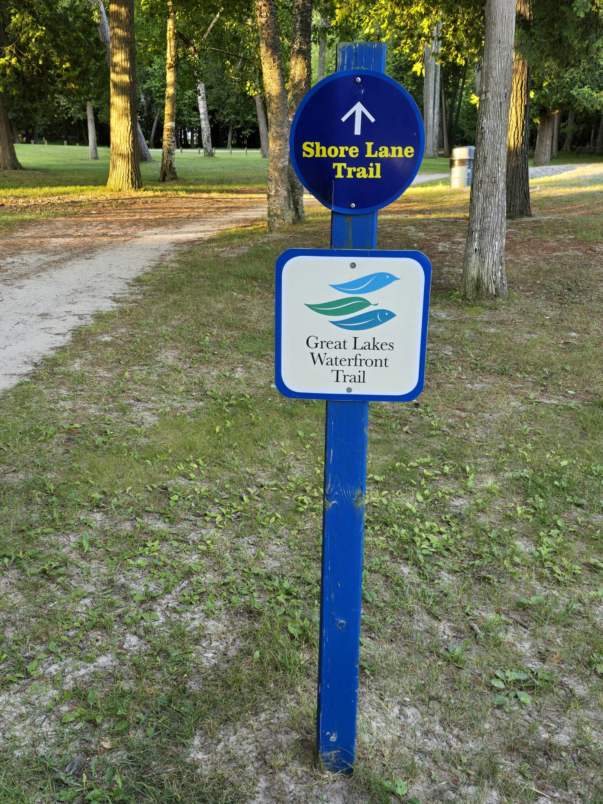 A bike trail with a sign saying Shore Lane Trail, Great Lakes Waterfront Trail.