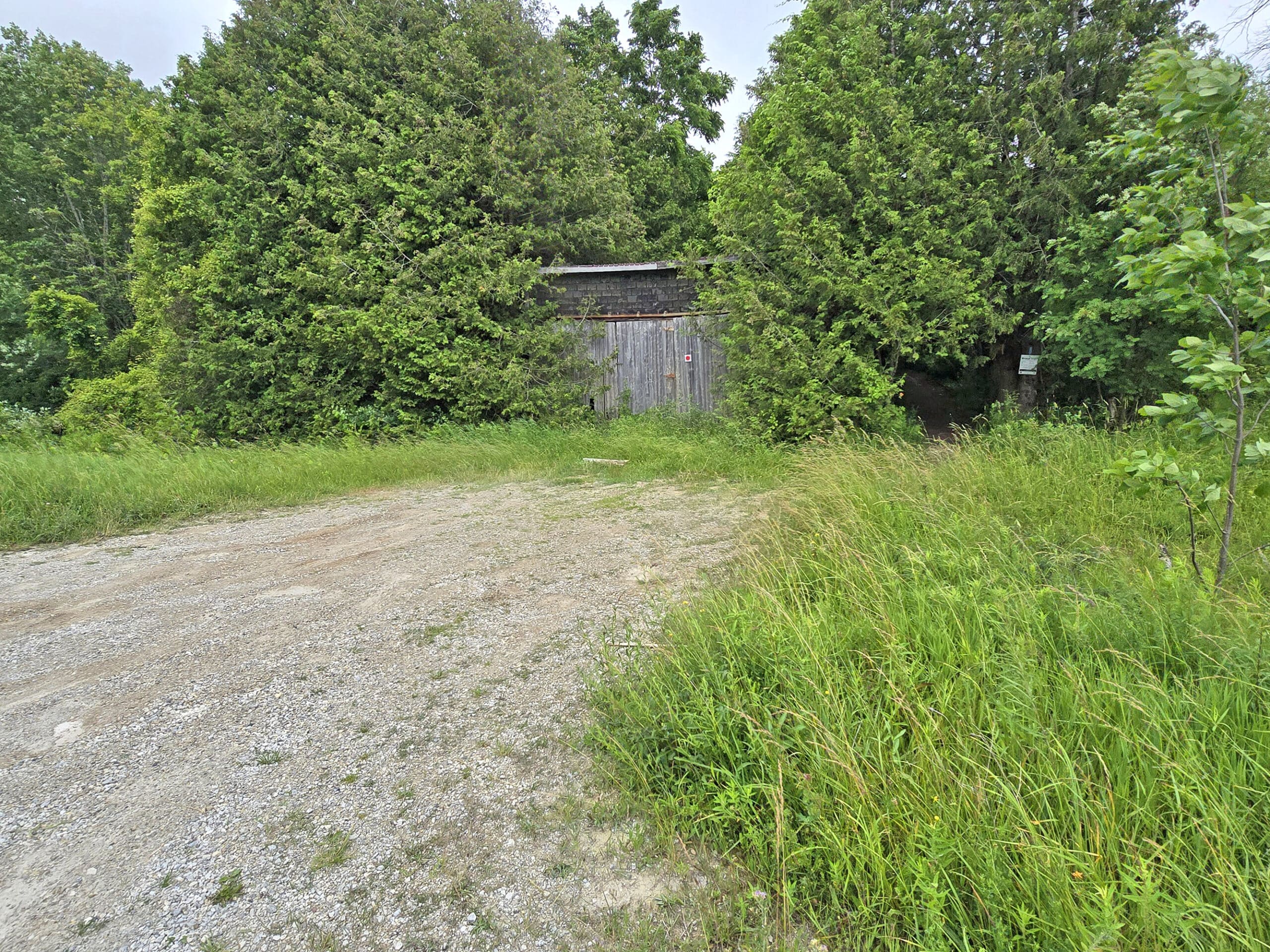 A small parking lot in front of a shack.