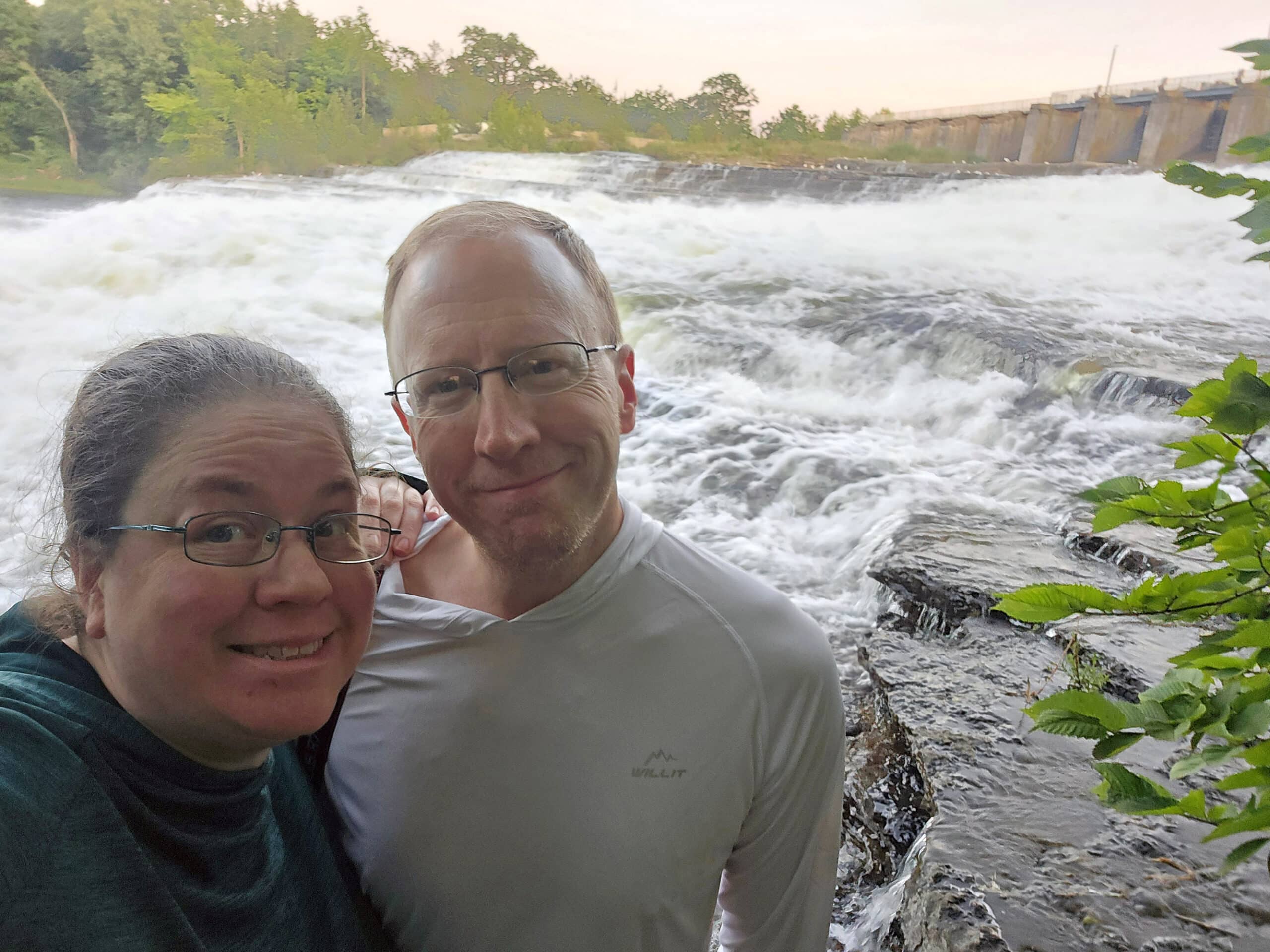 A middle aged couple taking a selfie in front of jhaley falls.