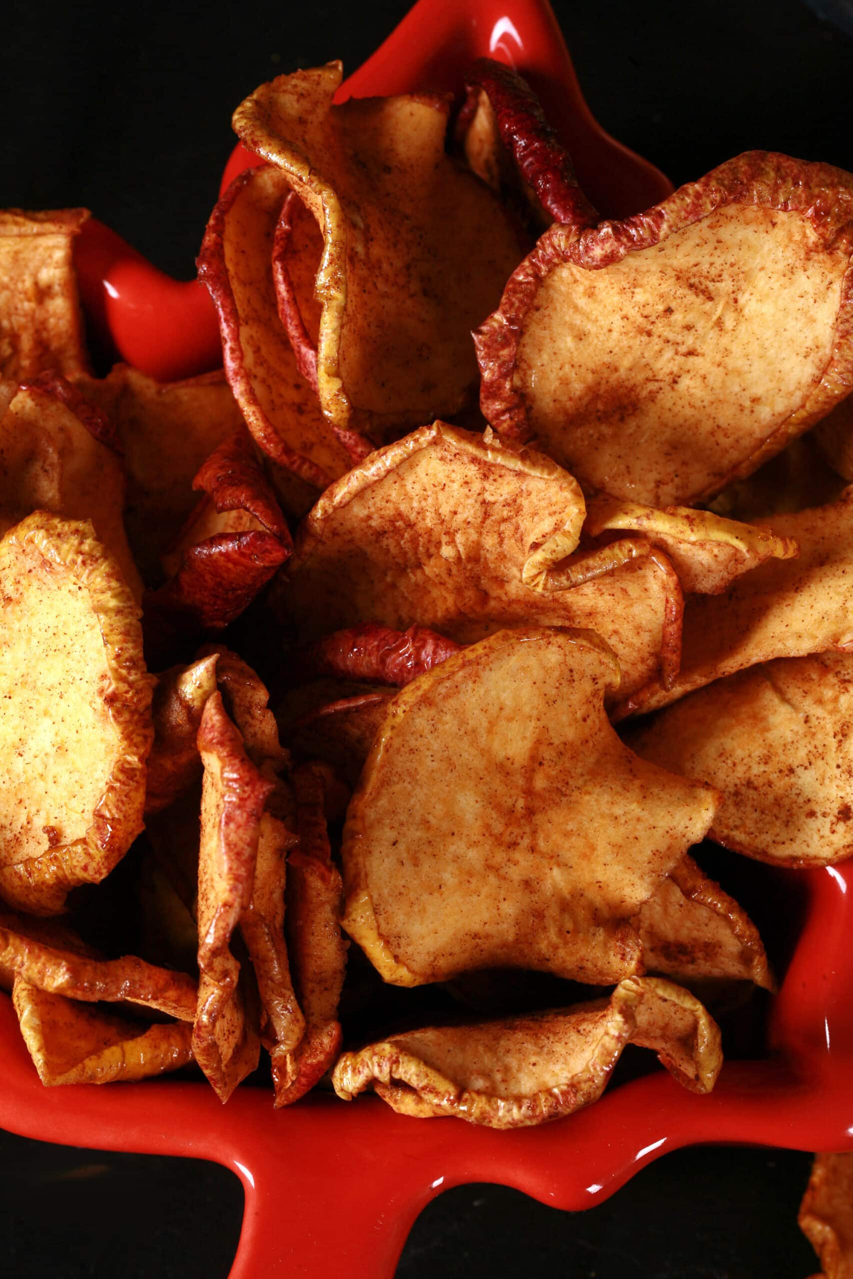 A bowl of homemade maple cinnamon dehydrated apple slices.