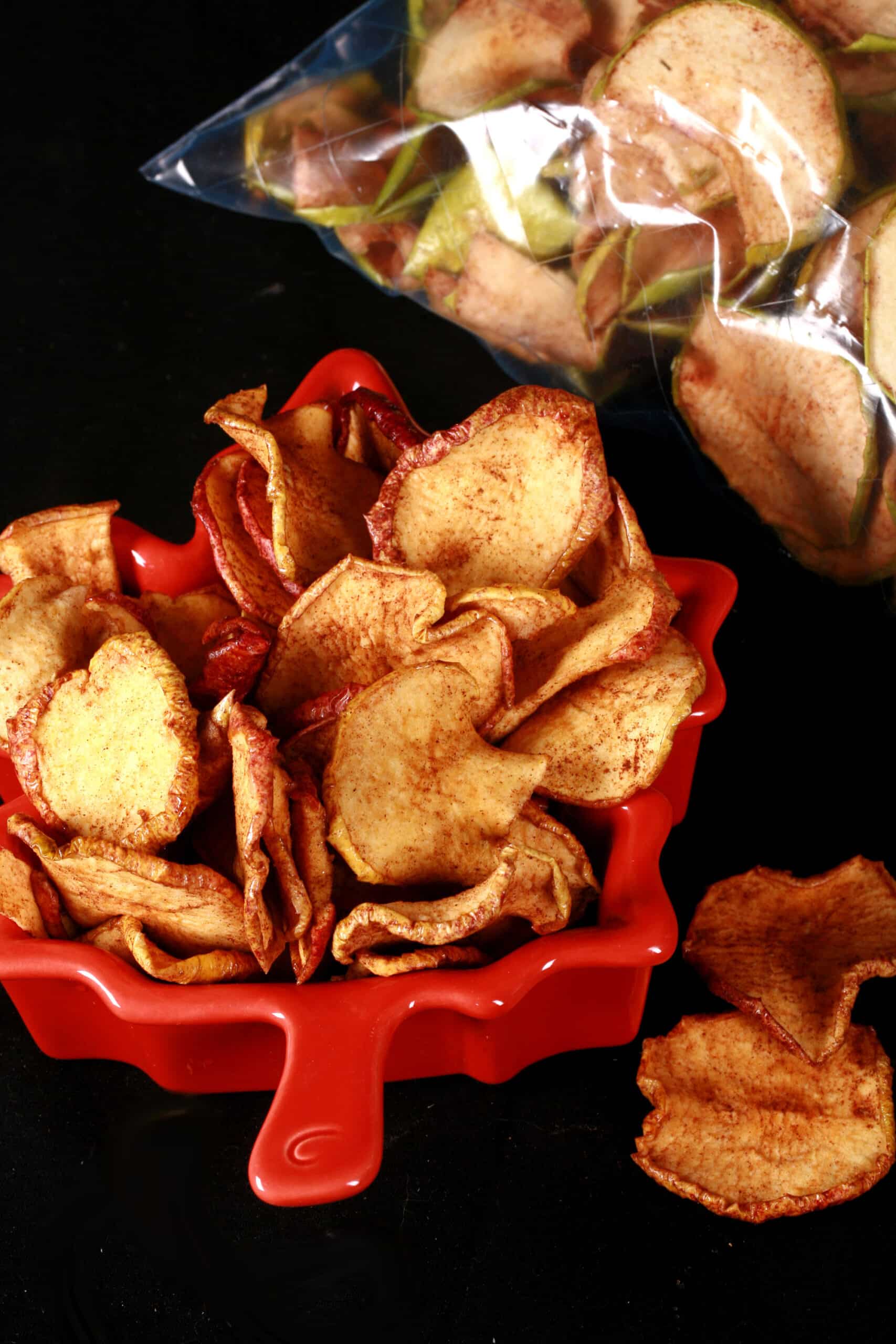 A bowl of homemade maple cinnamon dehydrated apple slices.