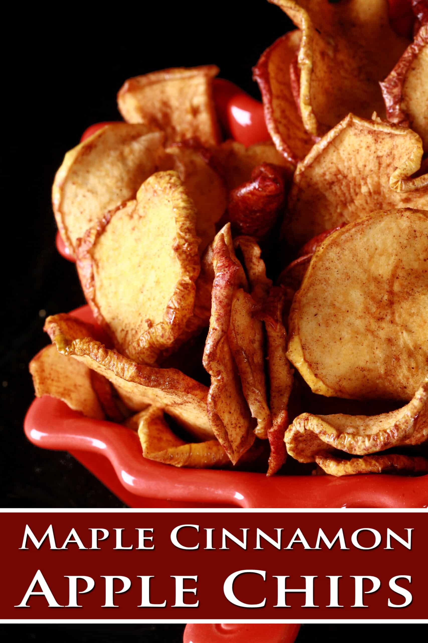 A bowl of homemade dehydrated apple slices. Overlaid text says maple cinnamon apple chips.