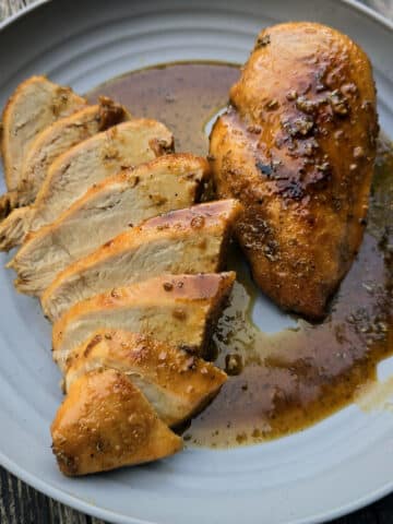 2 rosemary maple chicken breasts on a plate.