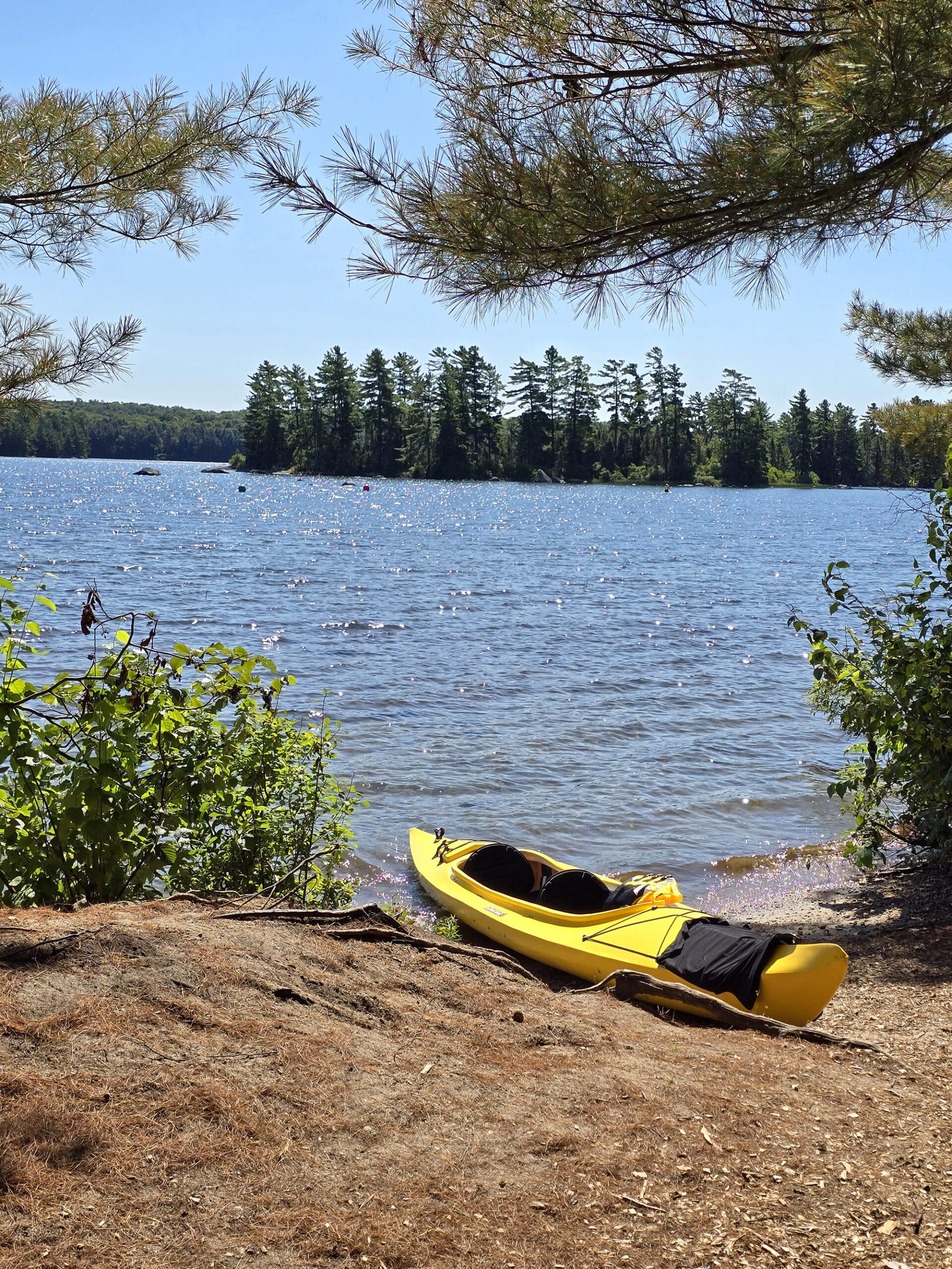 A yellow kayak on the shore of Eagle Lake.