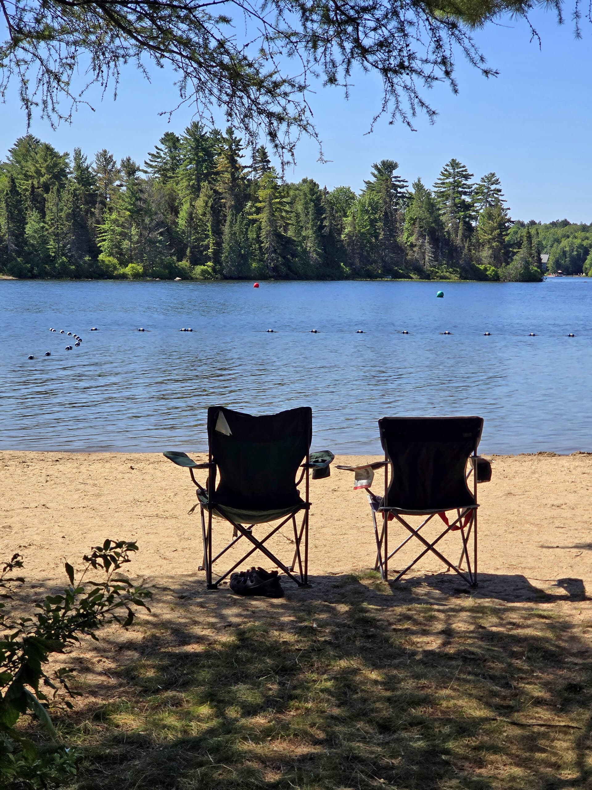 2 camping chairs on a beach at Mikisew provincial park.