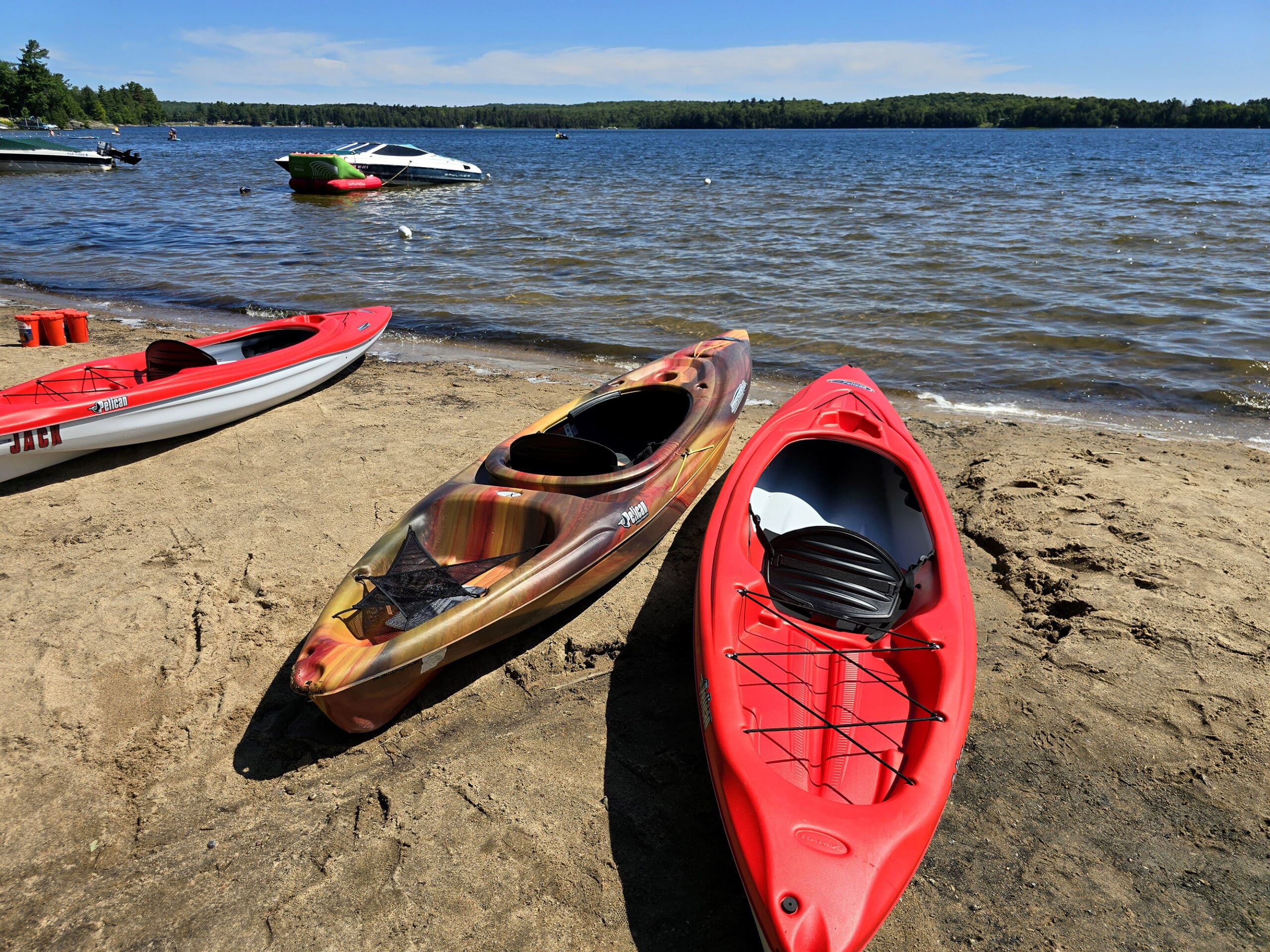 Several Kayaks on a sandy beach at Mikisew Provincial Park.