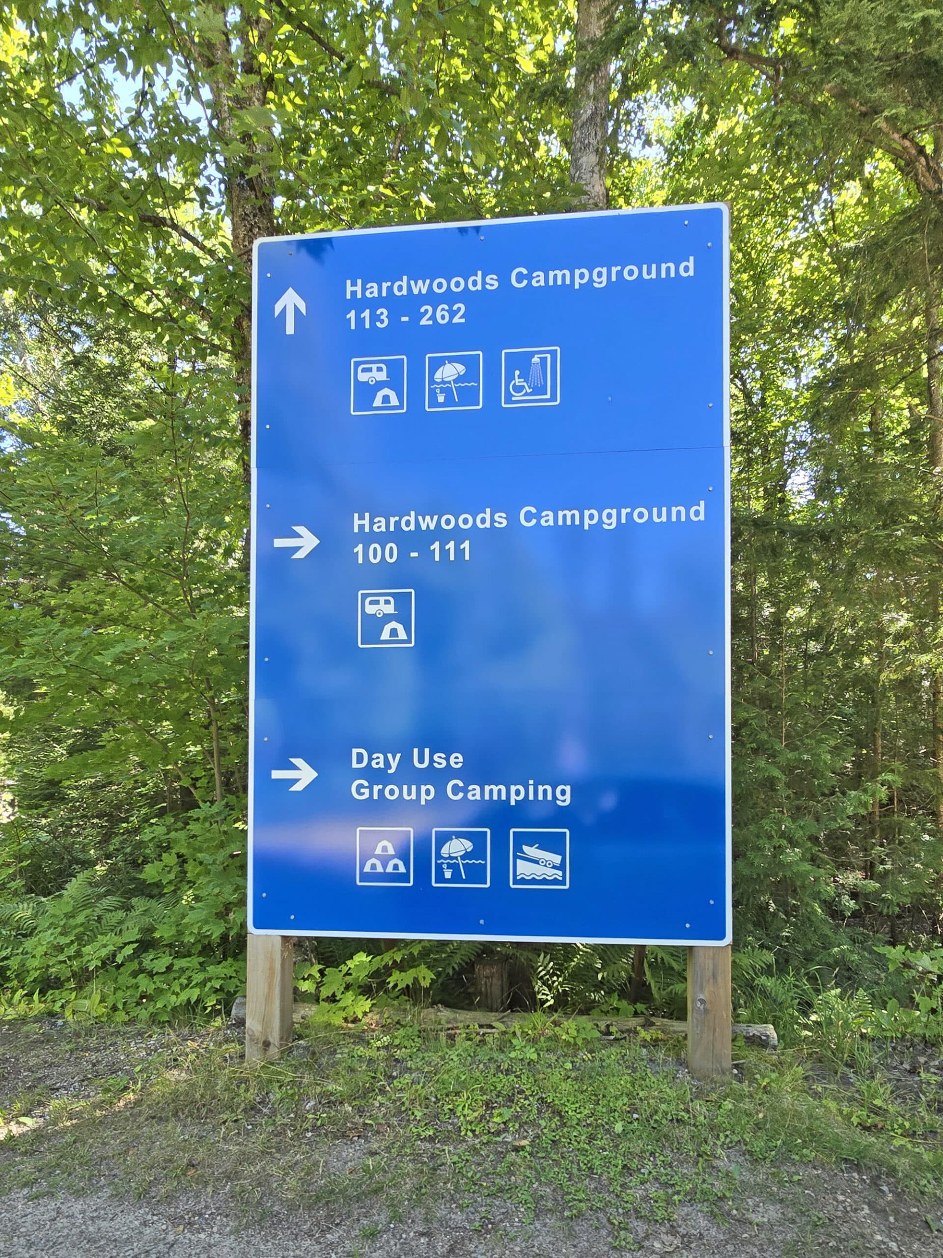 A large blue campground direction sign, with white lettering.