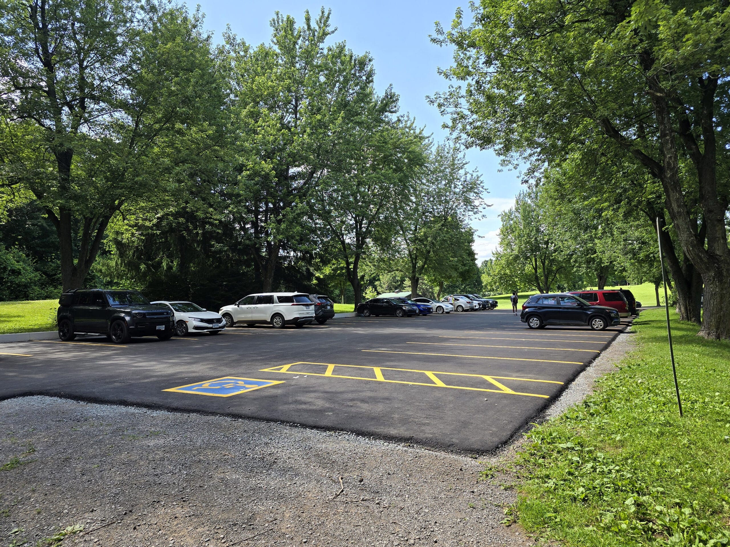 A small parking lot, half full of cars.