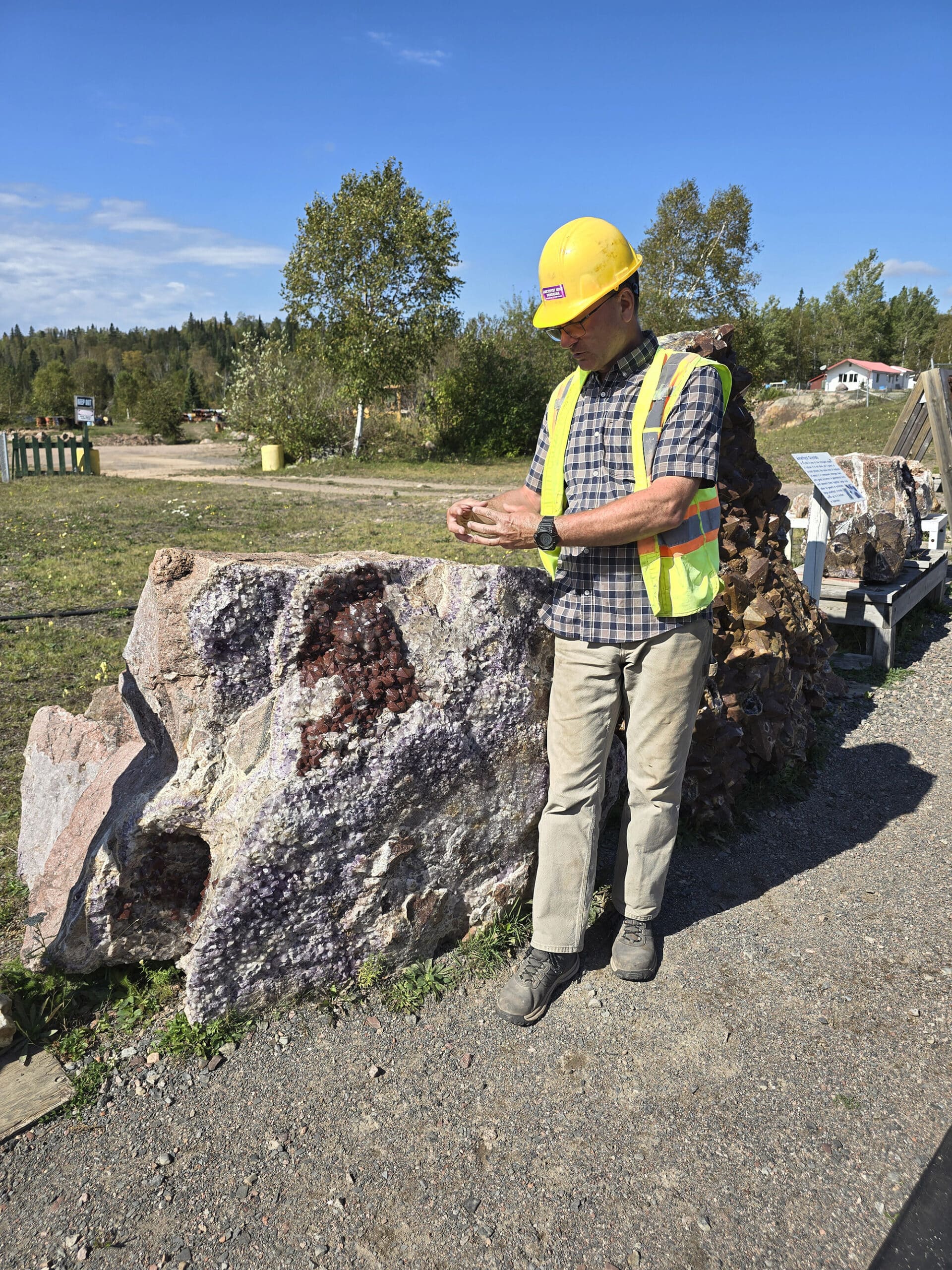 A man in work gear conducting a tour of the amethyst mine panorama.