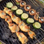 Mediterranean Chicken Kebabs with skewers of zucchini and mushrooms on a grill.