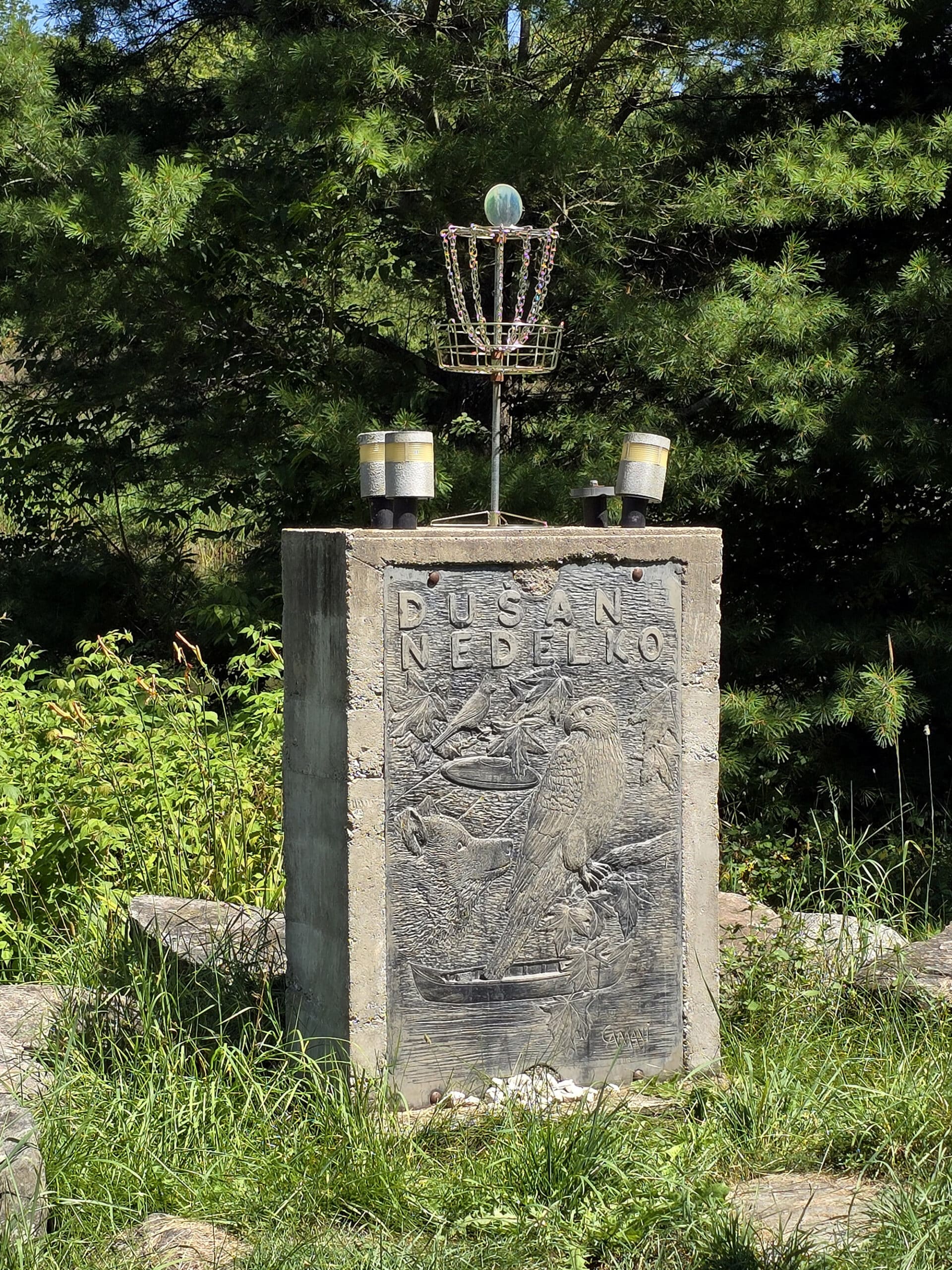 A monument with a Disc Golf basket on top.