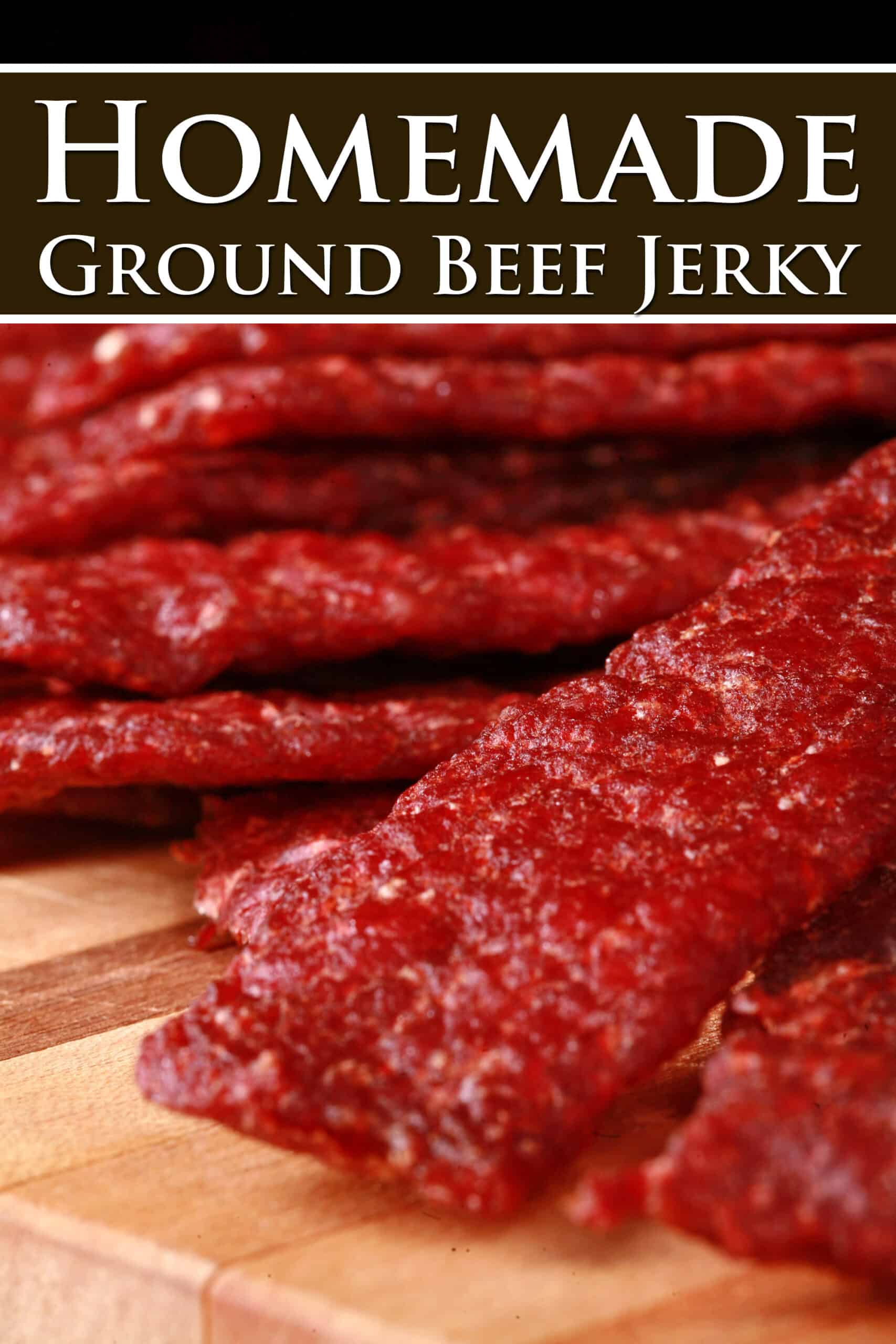 A pile of homemade beef jerky strips on a wooden cutting board.  Overlaid text says homemade ground beef jerky.