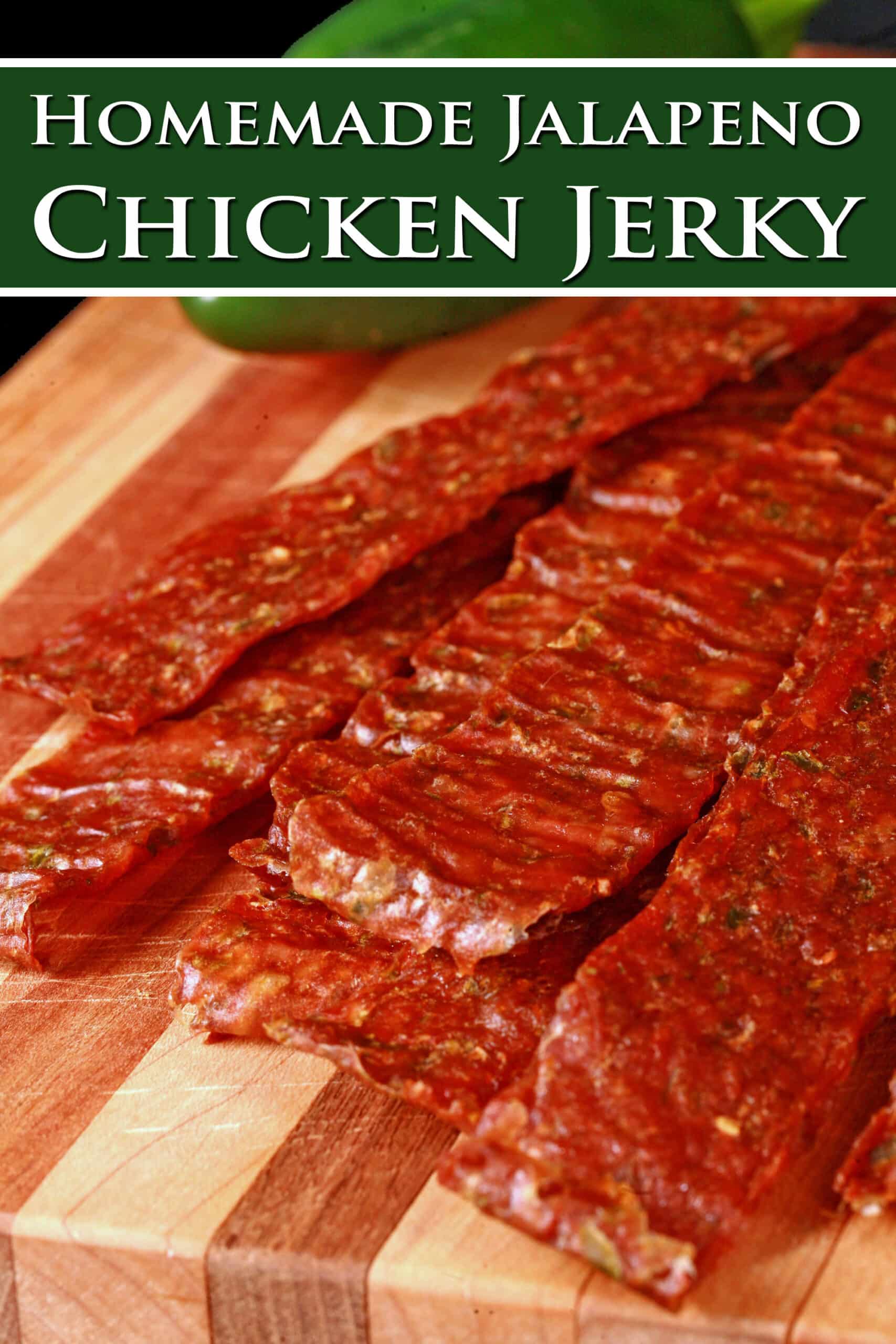 A pile of homemade chicken jerky on a wooden cutting board, along with 2 jalapenos. Overlaid text says jalapeno chicken jerky.